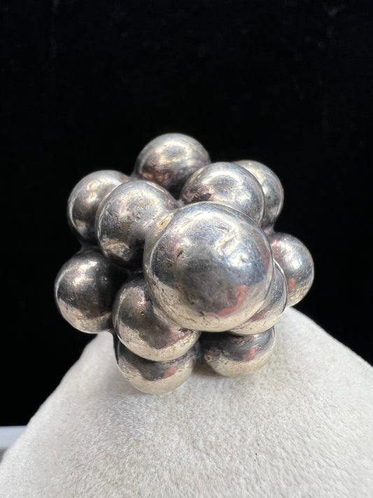 Crafted from sterling silver, this vintage Mexican ring features a distinctive design that highlights traditional artistry. Its bubble motif adds texture and depth, making it a unique accessory.