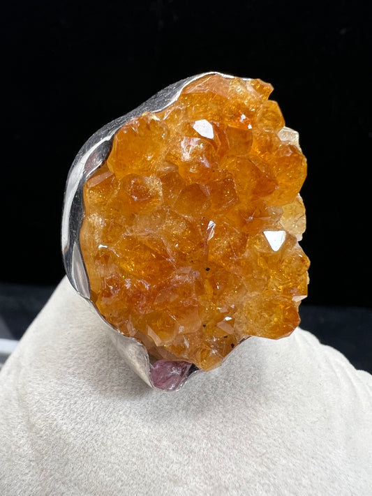 This sterling silver ring by Charles Albert showcases a striking 1 1/4" citrine specimen, combining expert craftsmanship with bold design. The large citrine centerpiece offers vibrant color and natural beauty, making it a distinctive accessory that will elevate any ensemble with refined elegance.