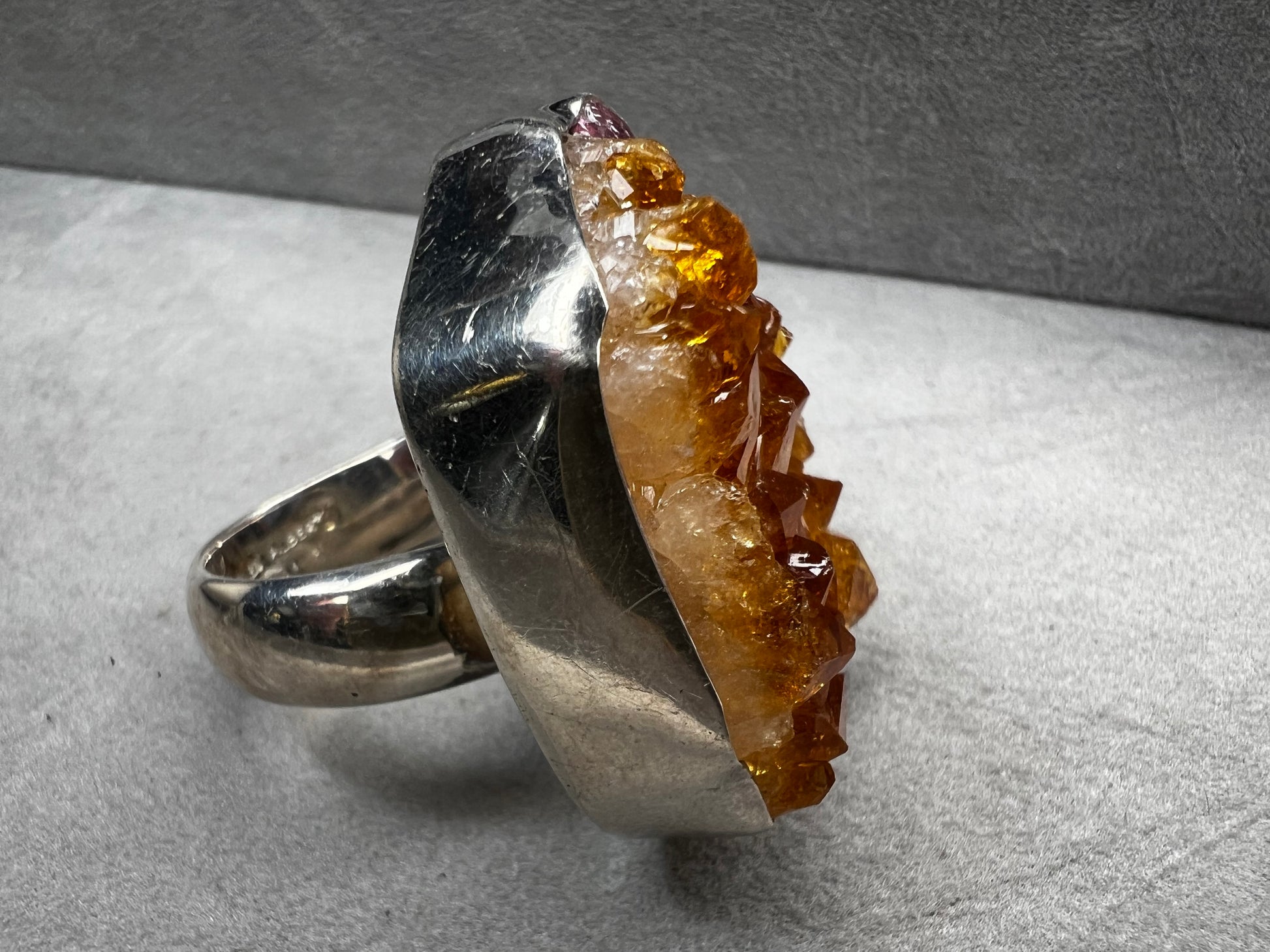This sterling silver ring by Charles Albert showcases a striking 1 1/4" citrine specimen, combining expert craftsmanship with bold design. The large citrine centerpiece offers vibrant color and natural beauty, making it a distinctive accessory that will elevate any ensemble with refined elegance.
