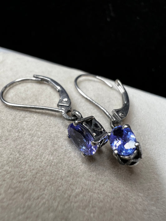 These sterling silver drop earrings feature a delicate tanzanite gemstone, adding a subtle splash of color and graceful movement to your look. Ideal for everyday wear or special occasions.