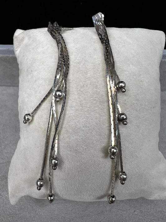 These sterling silver dangle earrings feature five chains of varying lengths, each adorned with a slide bead that moves gracefully with you. Their dynamic design adds elegant motion to your look, making them a charming accessory for any occasion.
