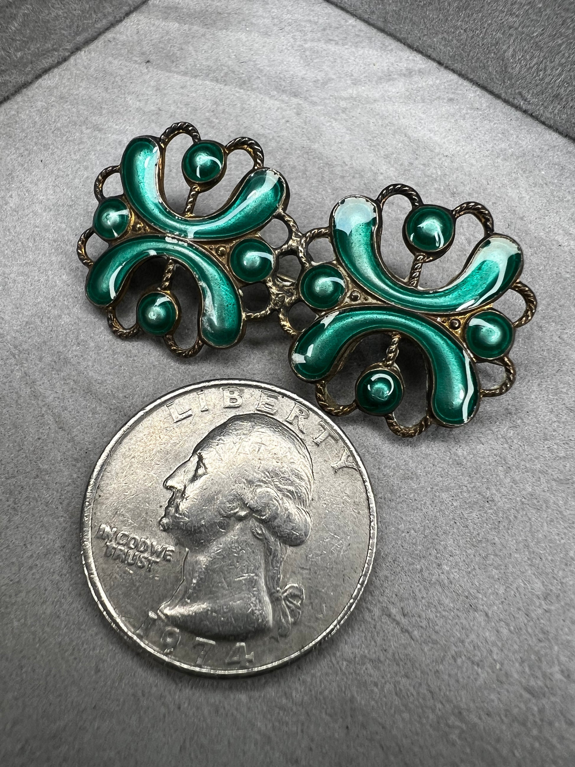 This antique sterling silver brooch features a unique candy green enamel that captures attention with its vibrant charm. A distinctive piece from the turn of the 20th century, it offers a one-of-a-kind style that sets you apart in any room.