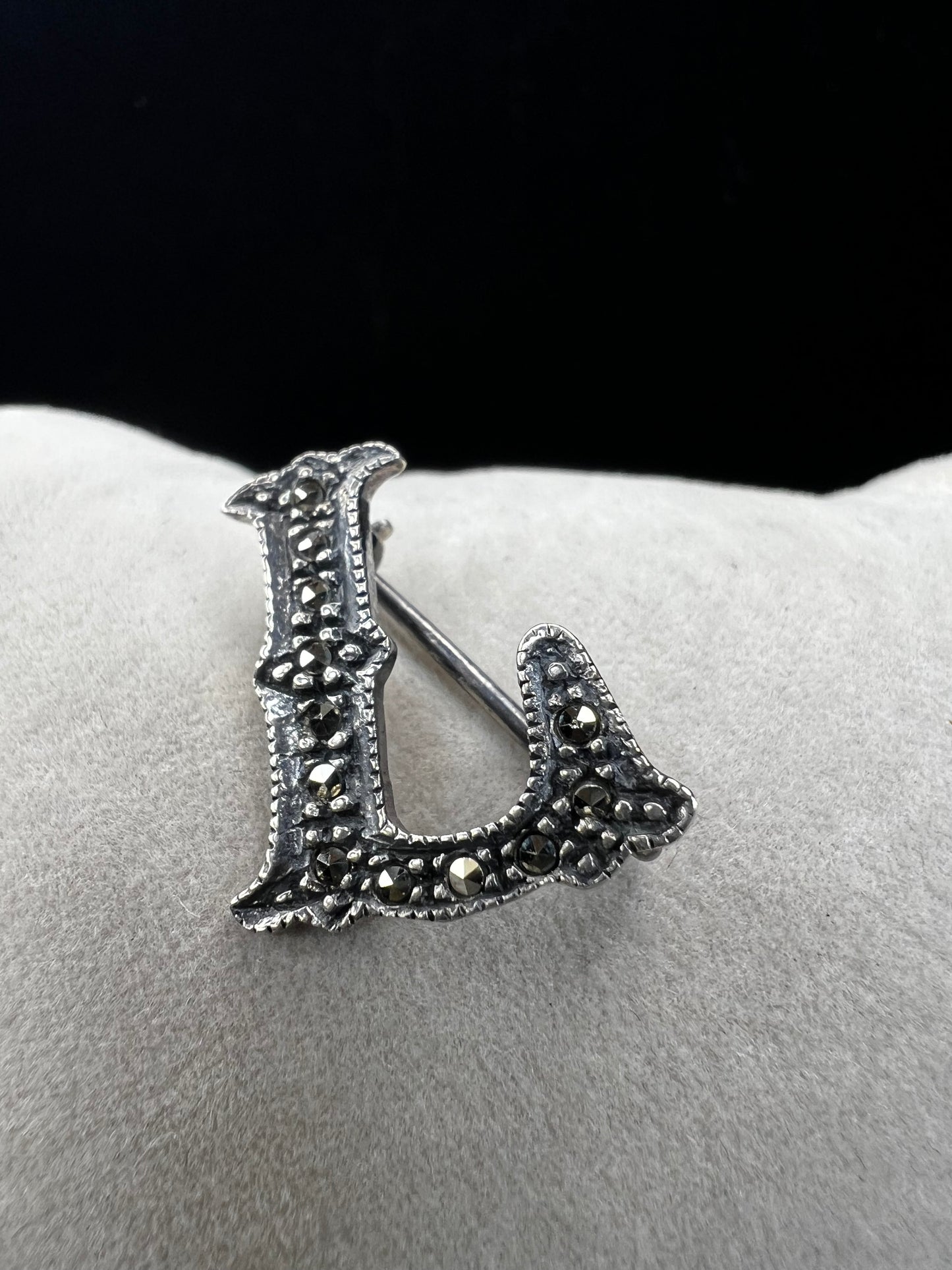 This sterling silver and marcasite pin shaped like an "L" adds a subtle, timeless vintage charm to any outfit. Its delicate design offers a perfect way to personalize your look with a touch of classic elegance.