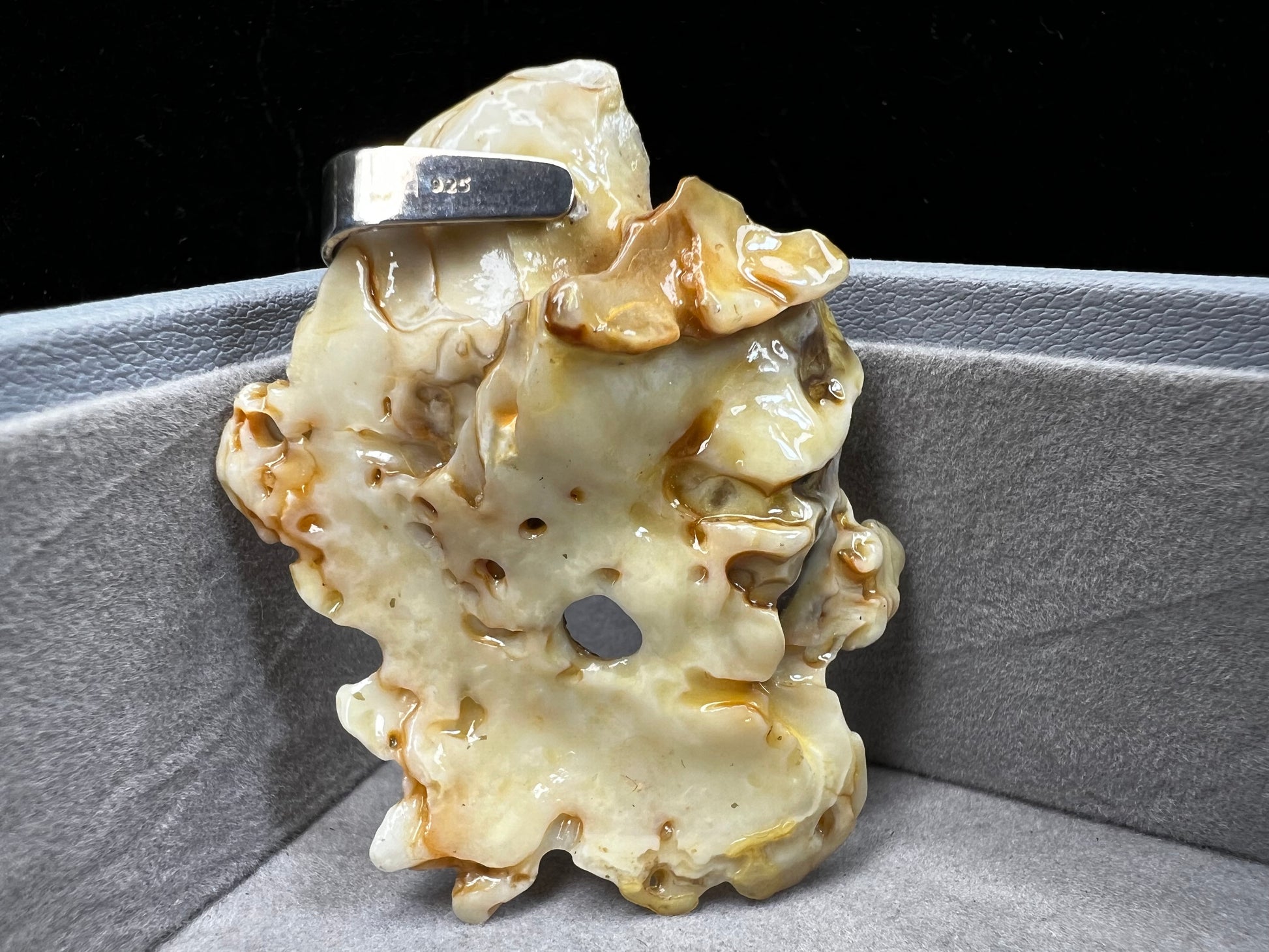 This pendant is crafted from a natural oyster and pearl, complemented by a sterling silver bail for a refined finish. Its unique design offers a special touch.