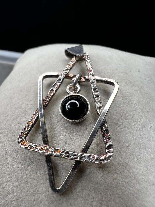 Crafted from sterling silver and marked Israel, this Star of David pendant features a striking jet cabochon delicately suspended in the center. Its thoughtful design combines tradition with elegance, making it a meaningful accessory that supports your personal expression of faith.