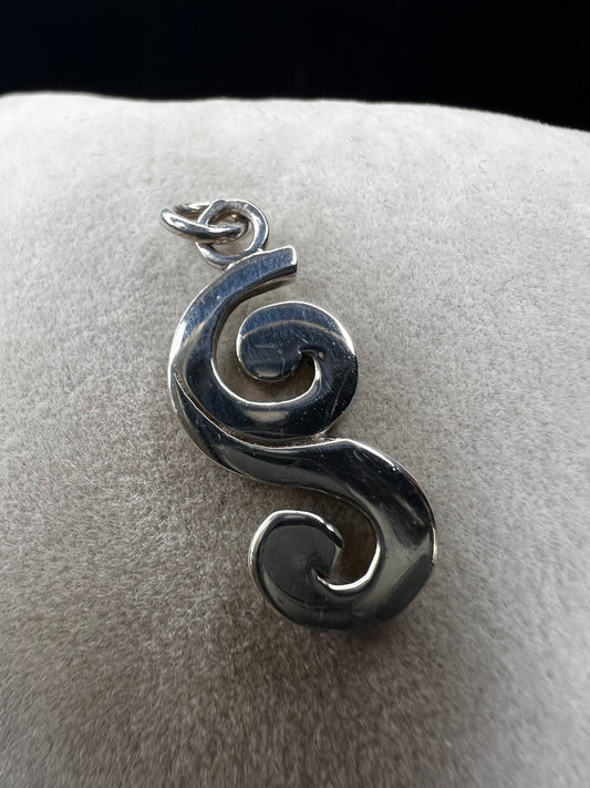 This sterling silver piece offers the flexibility to be worn as a charm or pendant, adapting effortlessly to your style. Signed Barse.