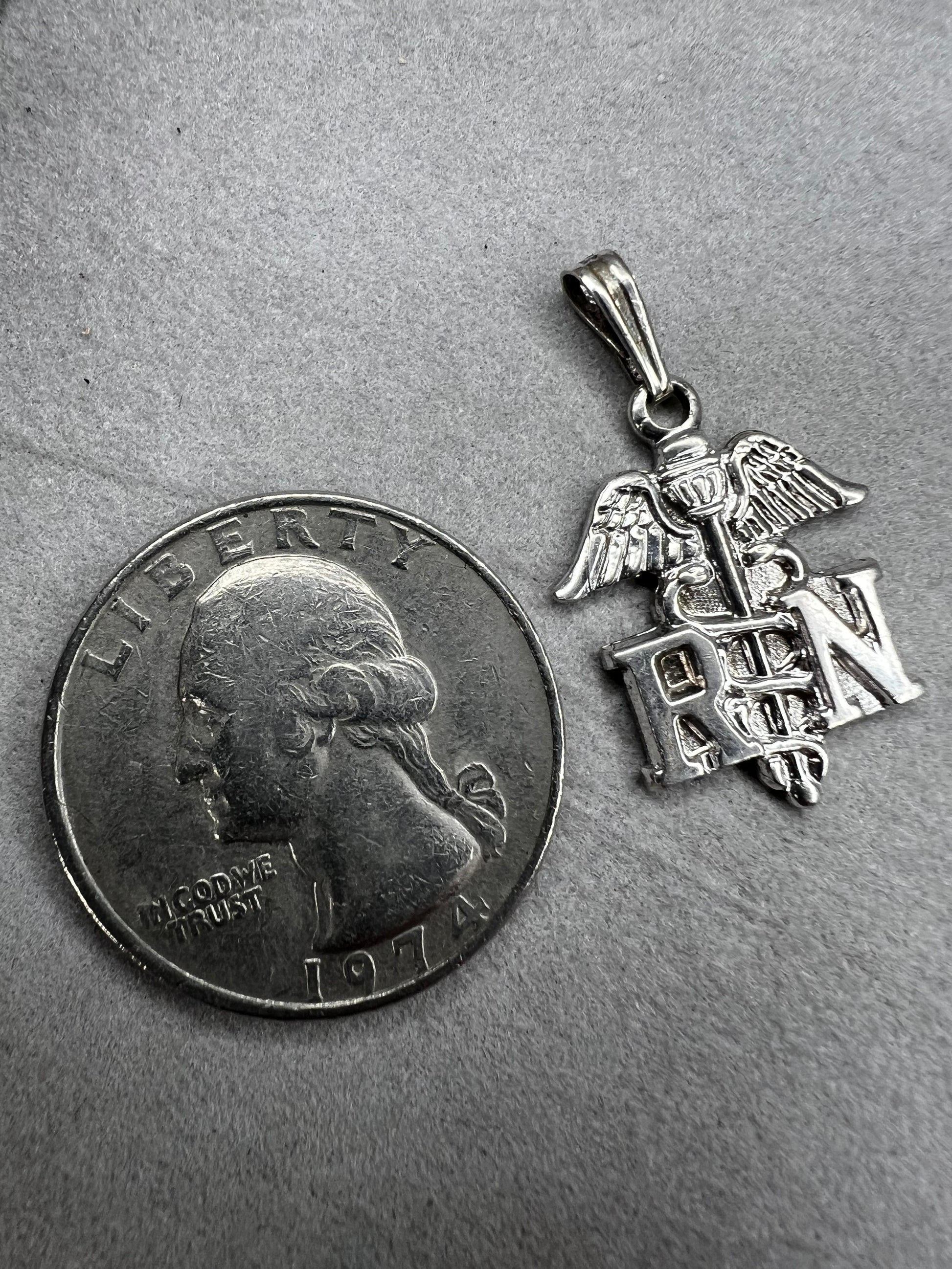 Celebrate the dedication of nurses with this vintage sterling silver RN pendant. It serves as a meaningful symbol of commitment and care. Perfect for everyday wear or as a thoughtful gift.