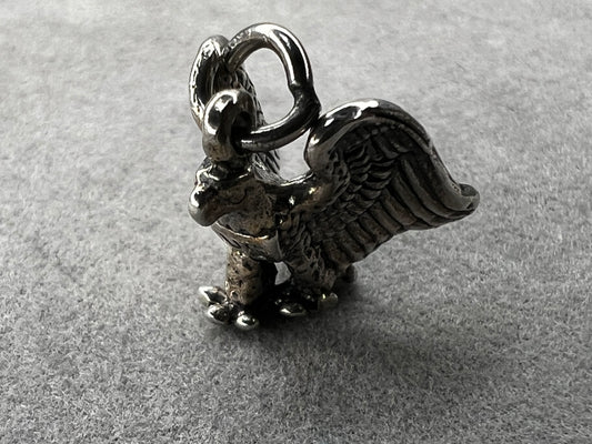 This eagle charm is expertly crafted from solid sterling silver. Its detailed design symbolizes strength and freedom, making it a perfect piece to celebrate your personal style and values.
