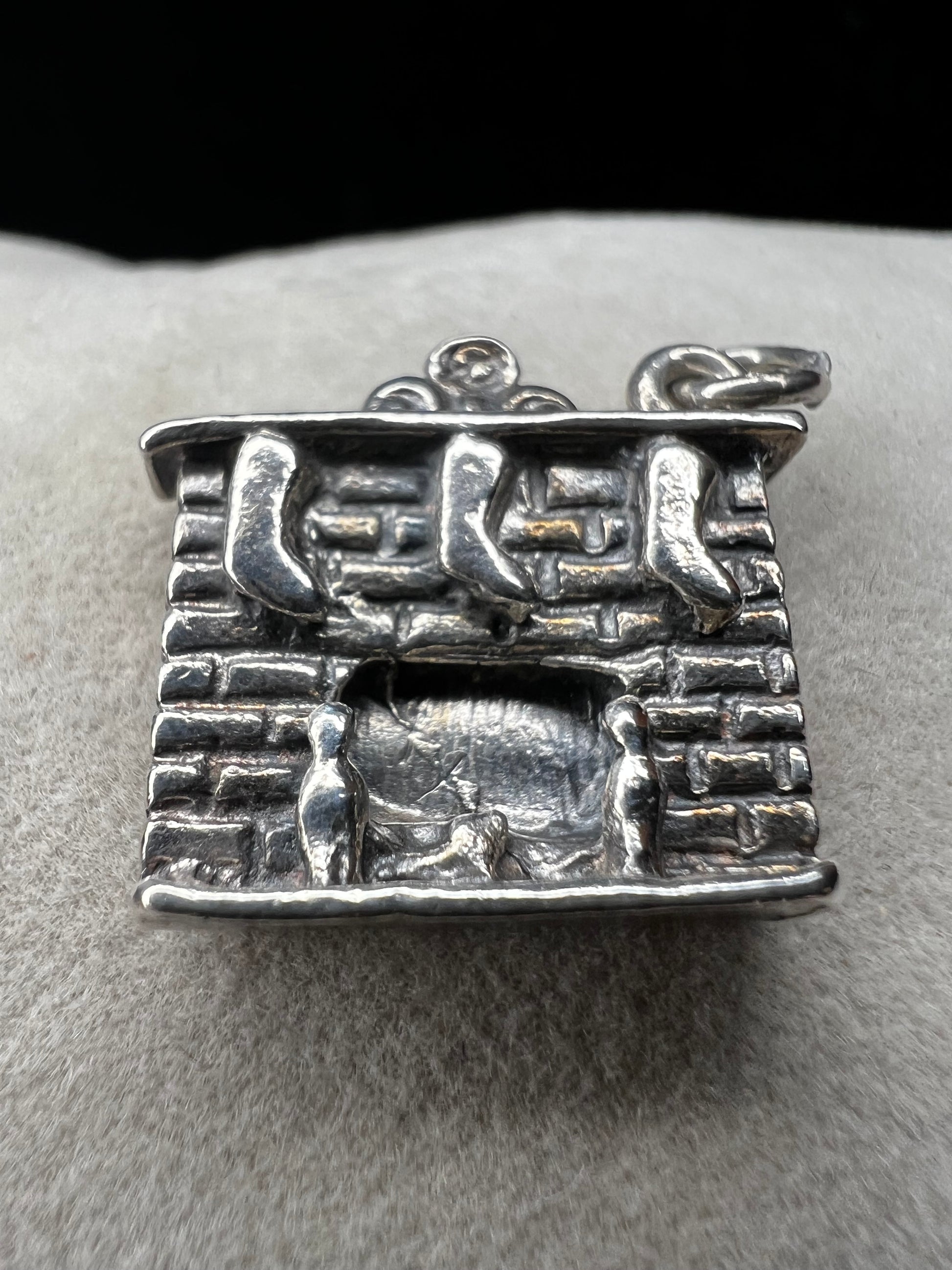 This Danecraft sterling silver charm captures the cozy holiday spirit with stockings hanging from the mantle above a wood-burning fire. It’s a charming addition to your Christmas collection, perfect for celebrating festive traditions and adding warmth to your jewelry.