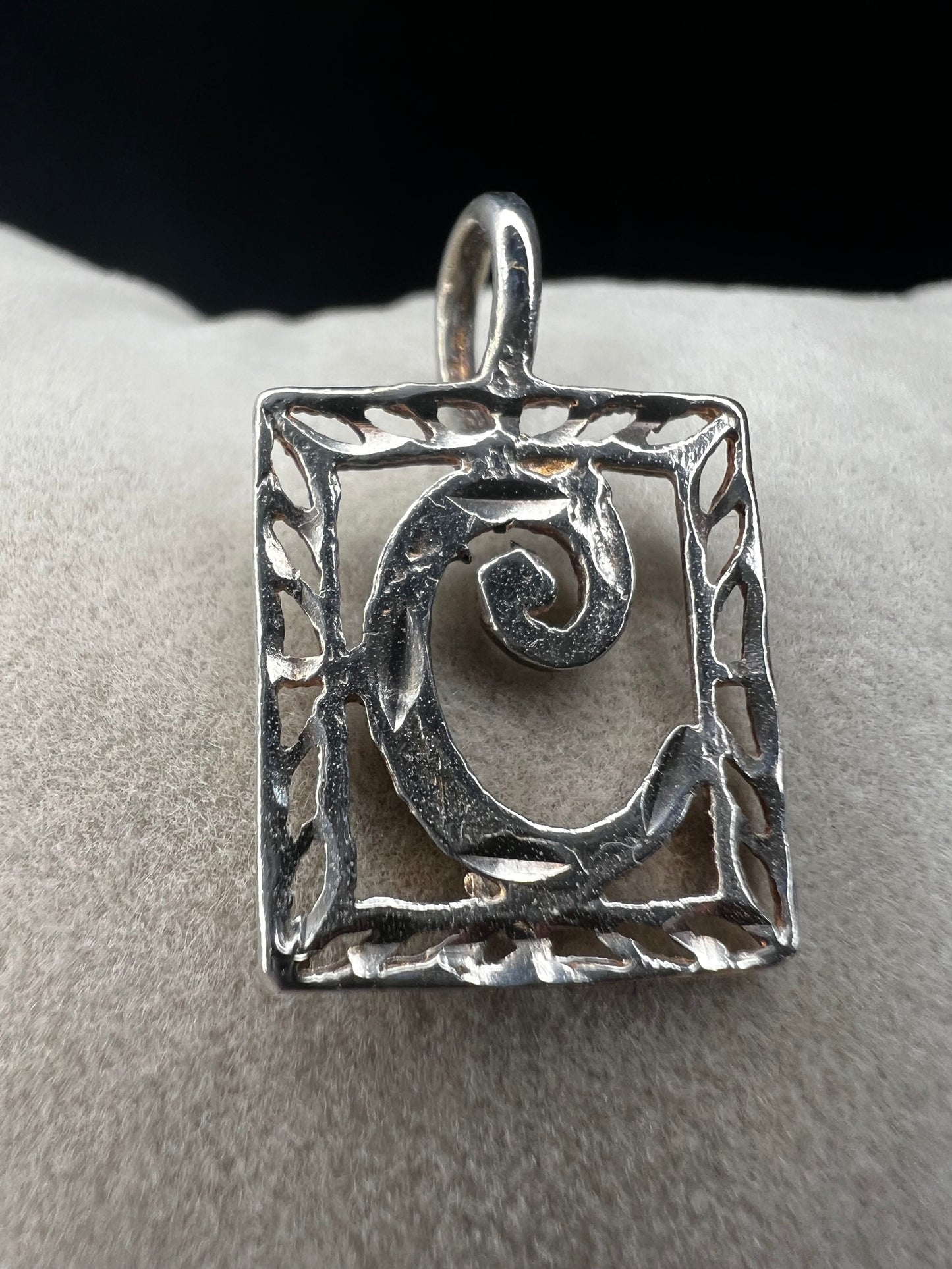 This sterling silver pendant features an elegant open work design with delicate diamond cuts, adding a refined touch to the classic "C" initial.