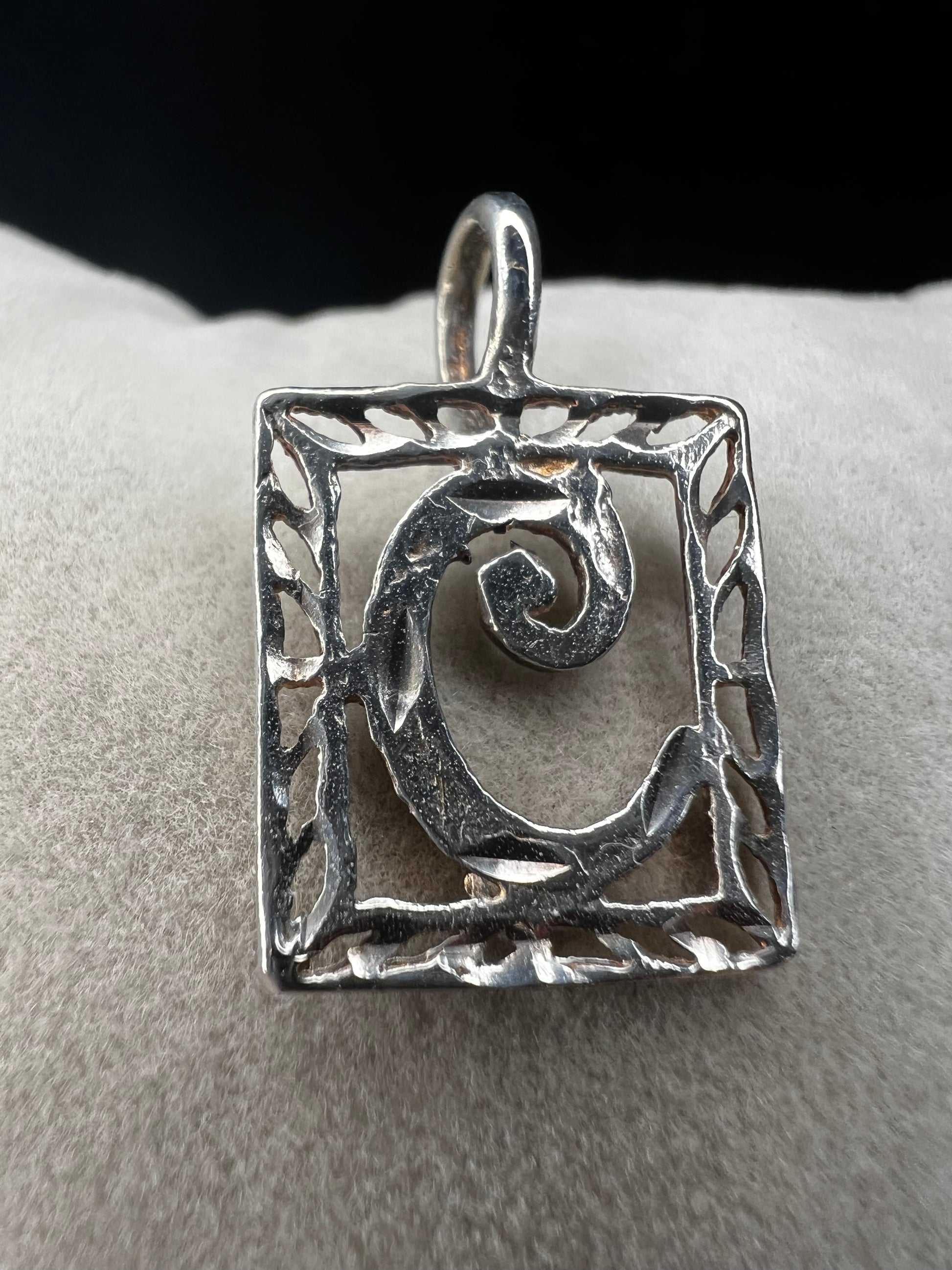 This sterling silver pendant features an elegant open work design with delicate diamond cuts, adding a refined touch to the classic "C" initial.