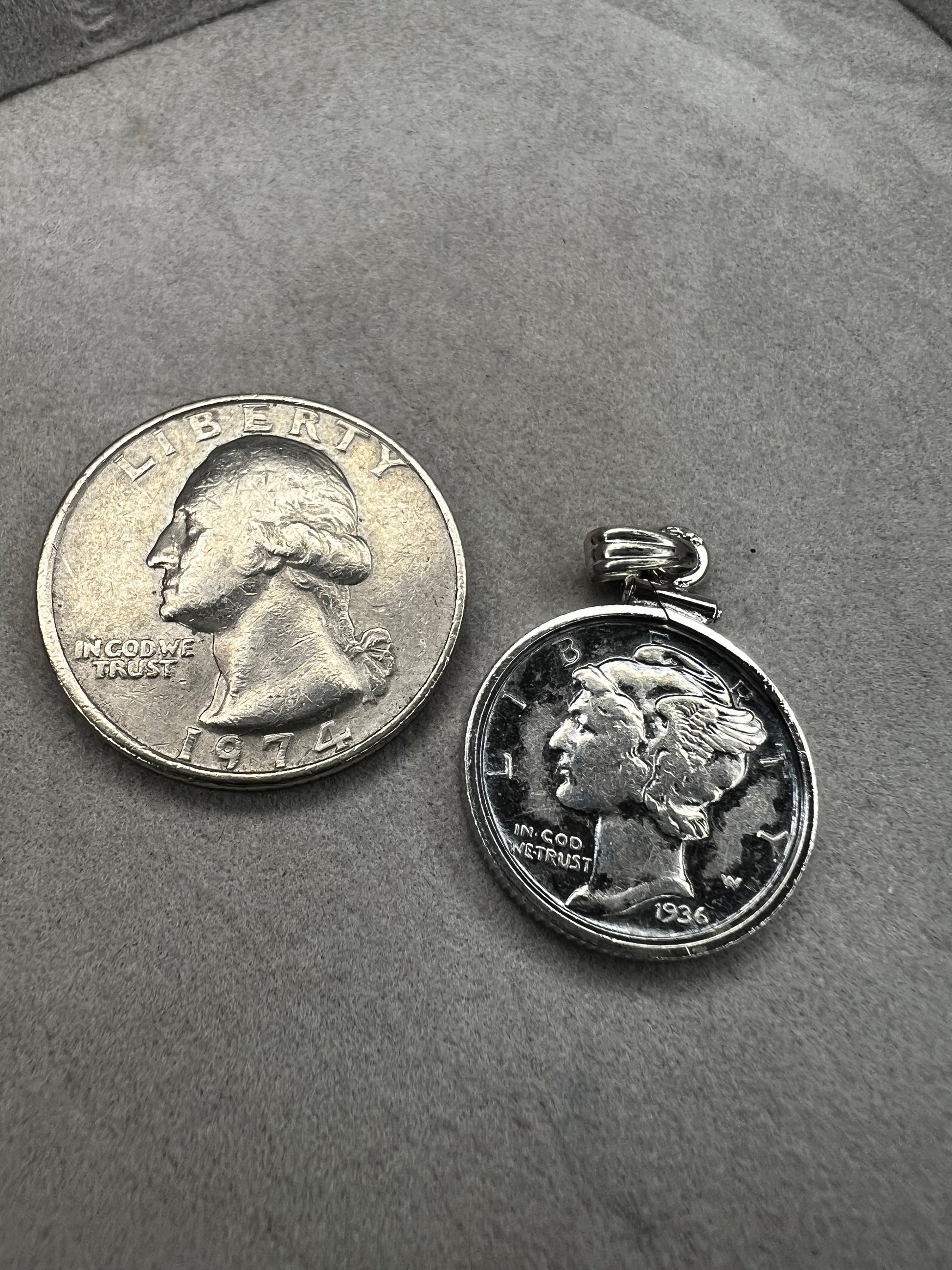 This pendant features a genuine 1936 silver Liberty Head dime, elegantly framed in sterling silver with a matching bail. It is a timeless accessory that combines historical charm with refined craftsmanship.