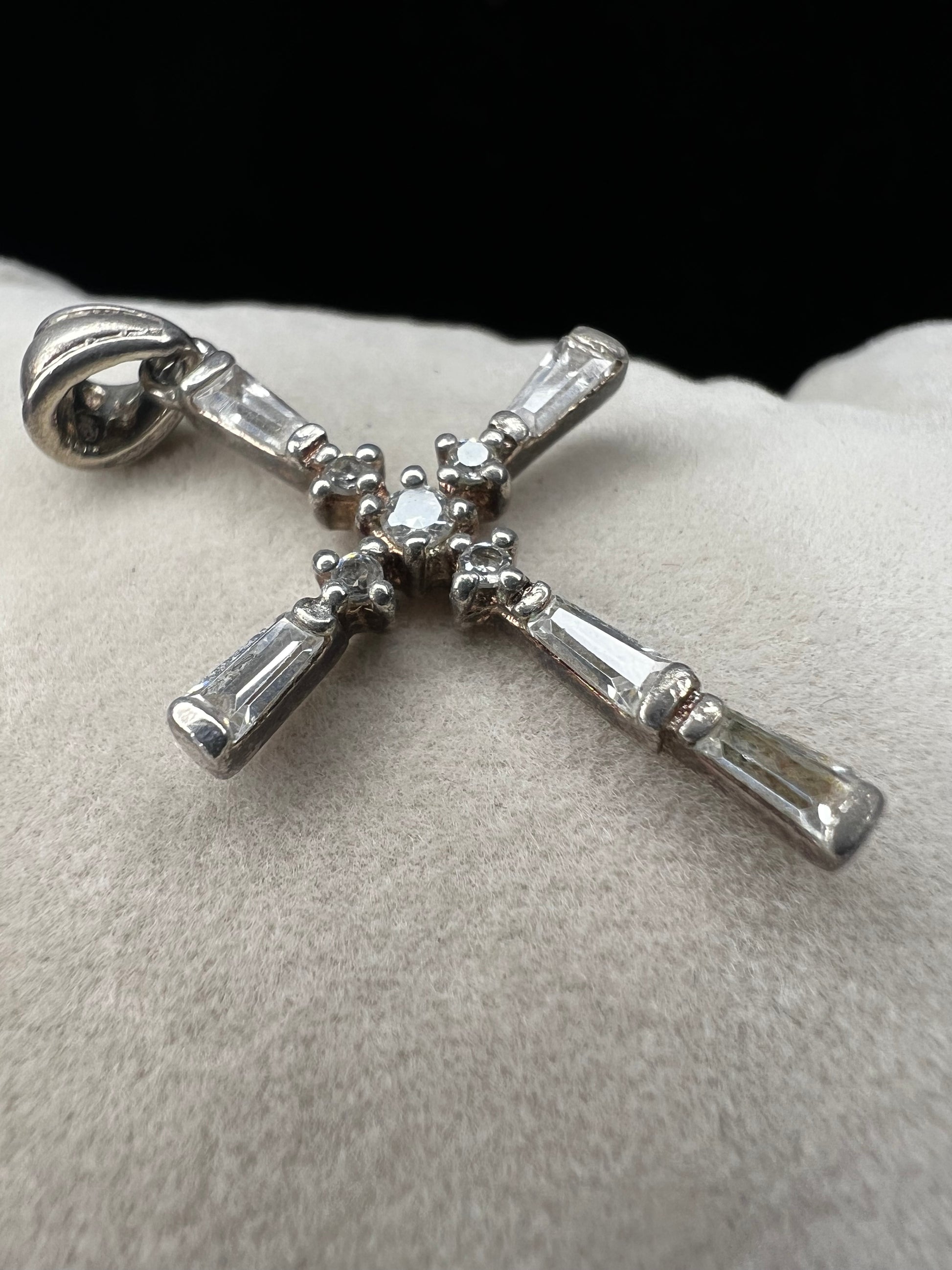 This vintage 1 1/4" sterling silver cross pendant features sparkling rhinestones that enhance its classic design.