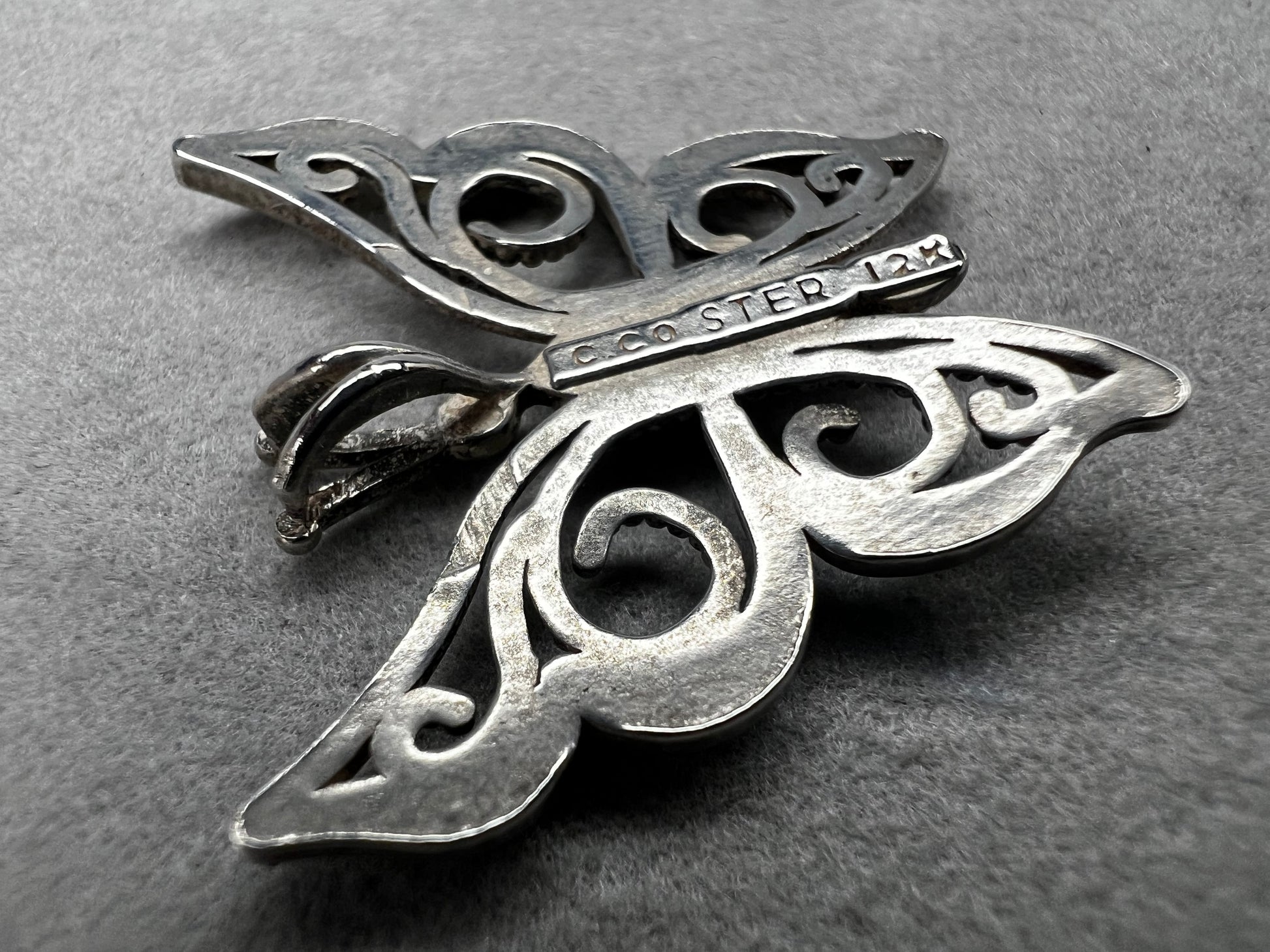This vintage butterfly pendant combines the timeless elegance of sterling silver with the rich warmth of 12 karat gold. Signed C. Co., this Black Hills Gold piece is perfect for those who appreciate classic craftsmanship with a touch of sophistication.