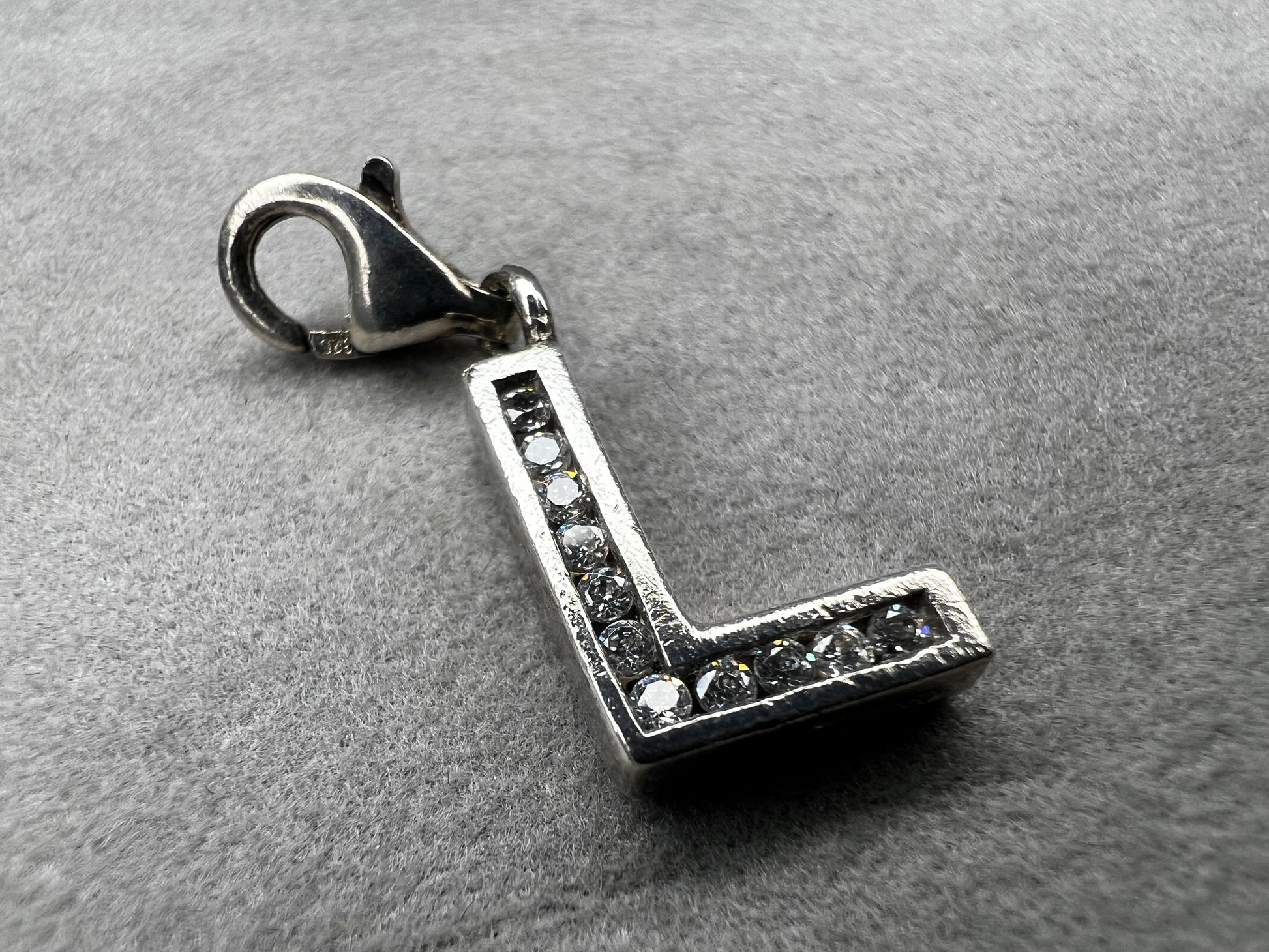 This Thomas Sabo sterling silver charm features the initial "L" elegantly adorned with sparkling cubic zirconia stones. This piece adds a subtle yet distinctive touch for anyone whose name begins with "L."