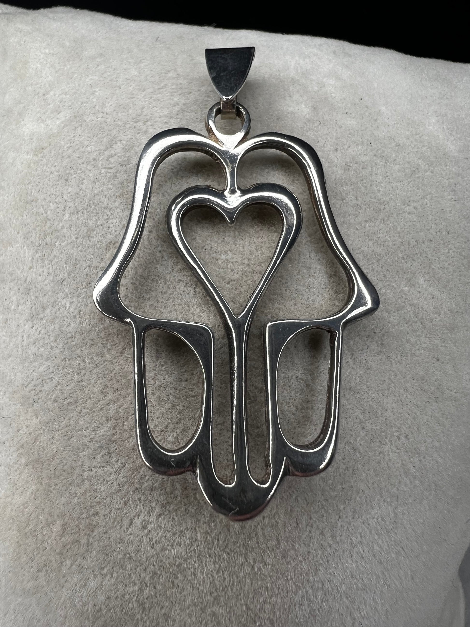 Crafted from sterling silver, this pendant is designed as a hamza hand, which is recognized by parts of the world as a symbol of protection. Made in Israel.