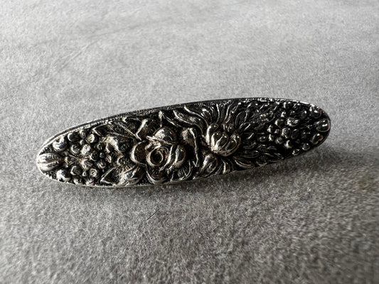 This antique Stieff Repousse sterling silver oval bar brooch showcases exquisite craftsmanship and timeless elegance. Despite its small size, it carries a distinguished charm that will add a touch of refined class to any collection.