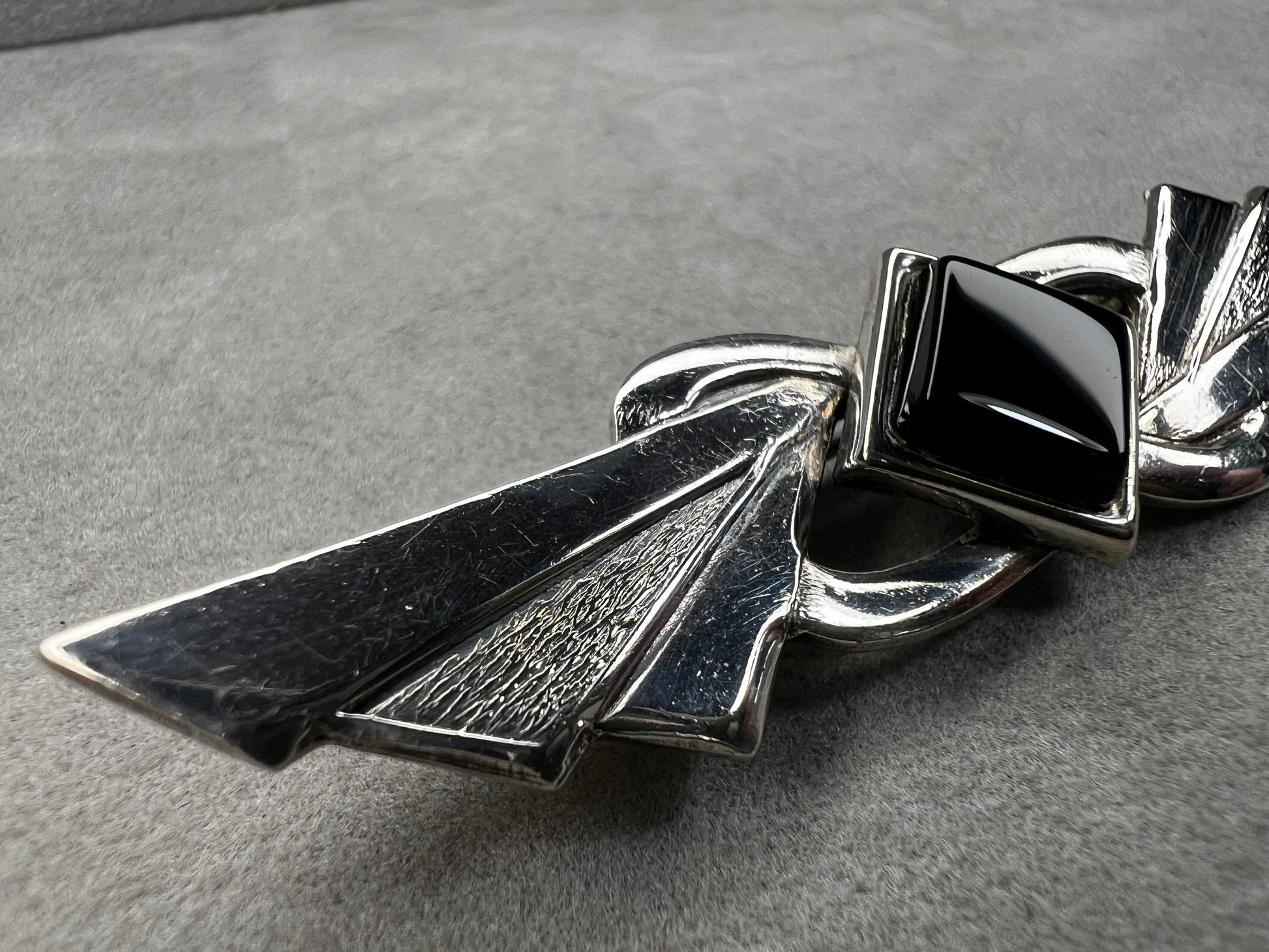 This vintage brooch is crafted from 800 silver and features a striking black diamond-shaped Jet centerpiece. Its classic design adds a sophisticated vintage touch to any outfit.