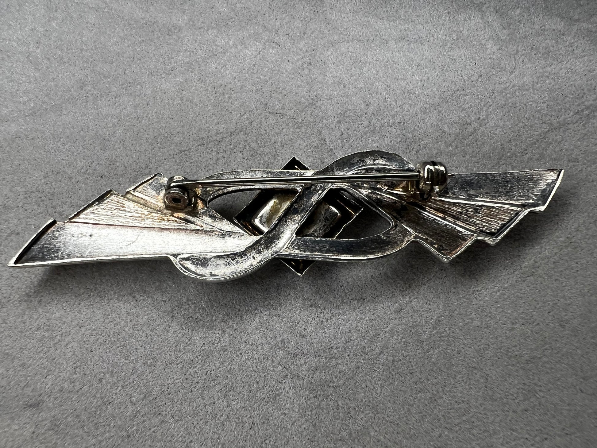 This vintage brooch is crafted from 800 silver and features a striking black diamond-shaped Jet centerpiece. Its classic design adds a sophisticated vintage touch to any outfit.