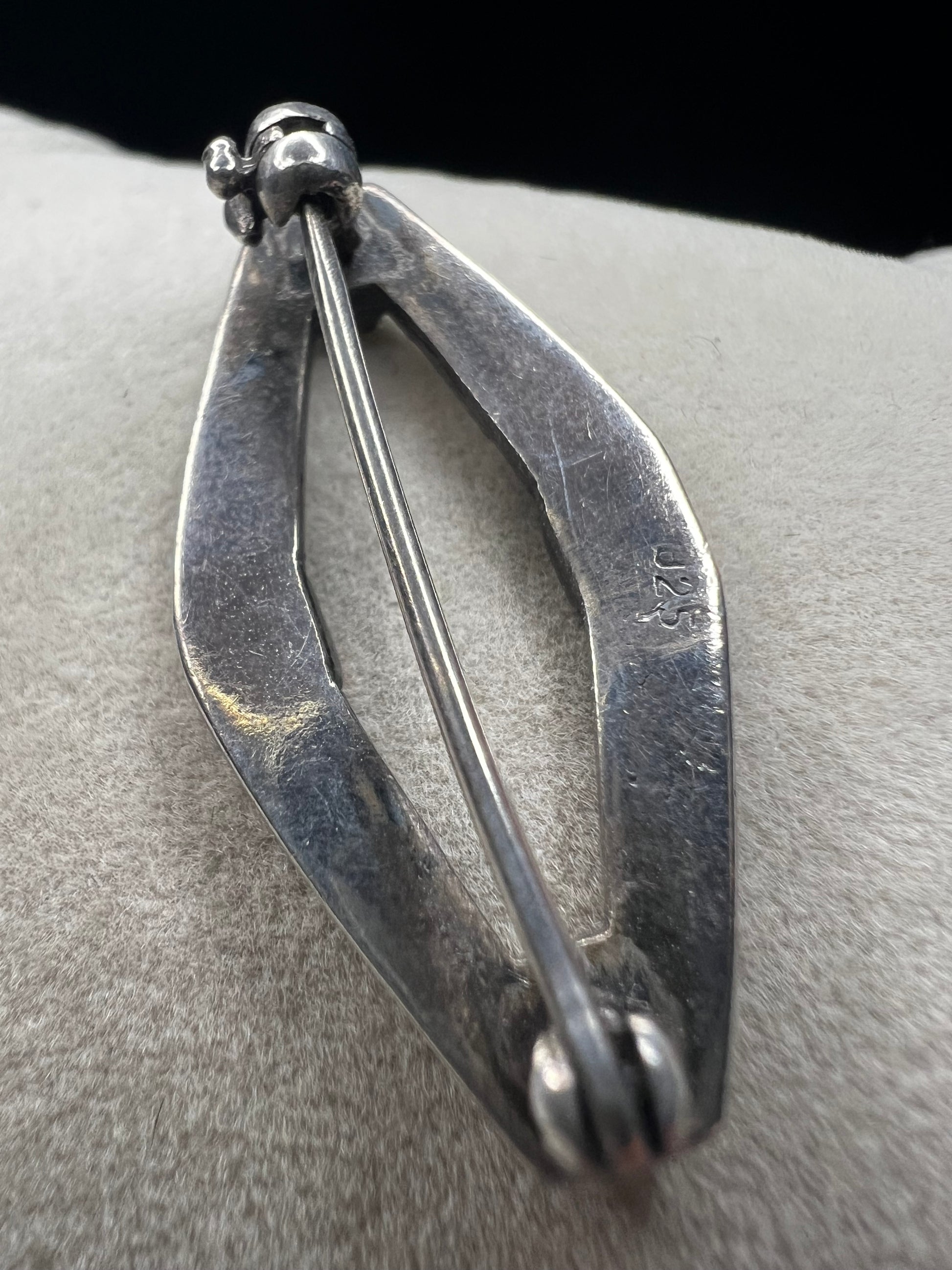 This vintage mid-century brooch combines sterling silver, marcasite, and enamel to create a timeless accessory. Its classic design adds a touch of elegance and history to any jewelry collection.