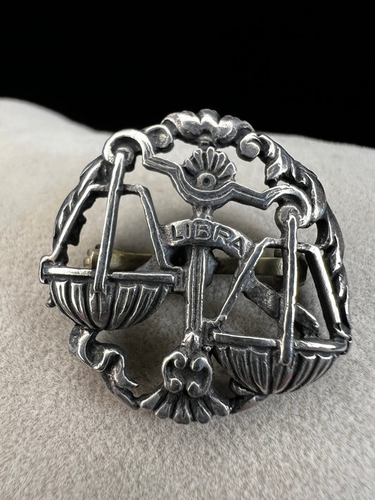 Celebrate the charm of the Libra zodiac sign with this vintage sterling silver brooch. Its timeless design makes it a thoughtful gift for anyone who appreciates astrology.