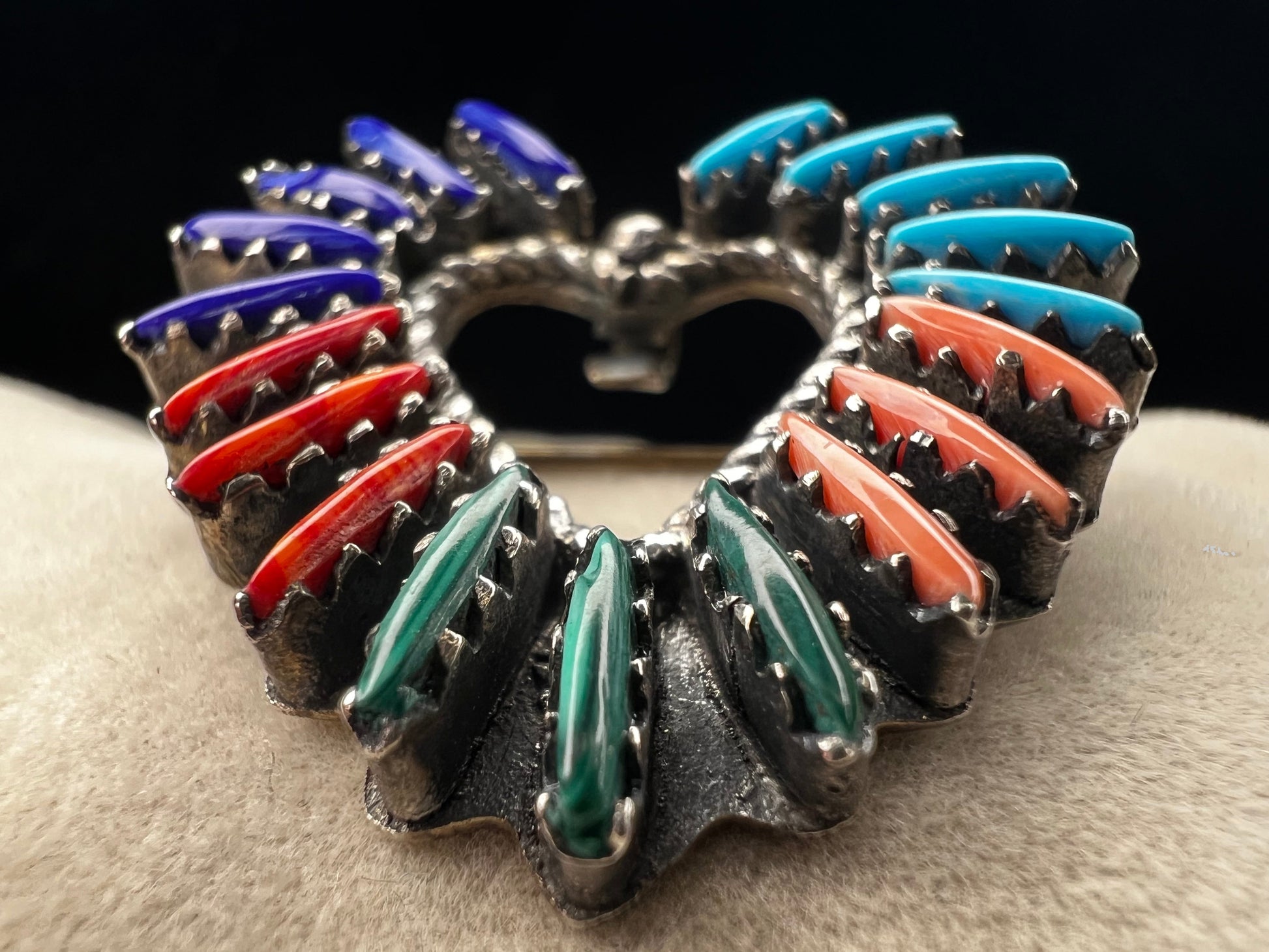 At just over an 1", this is a beautiful vintage Navajo pin done by Tom Taylor, meticulously crafted from sterling silver and natural stones. This is a special piece. There are small chips in some of the stones, but they don't take away from the pin's beauty.