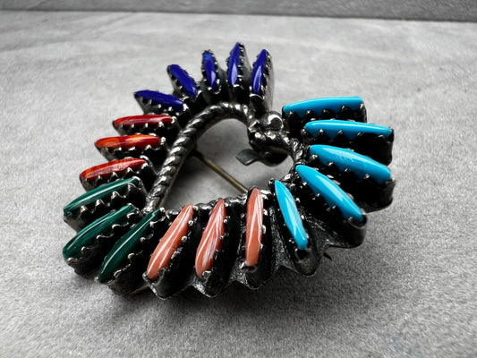 At just over an 1", this is a beautiful vintage Navajo pin done by Tom Taylor, meticulously crafted from sterling silver and natural stones. This is a special piece. There are small chips in some of the stones, but they don't take away from the pin's beauty.