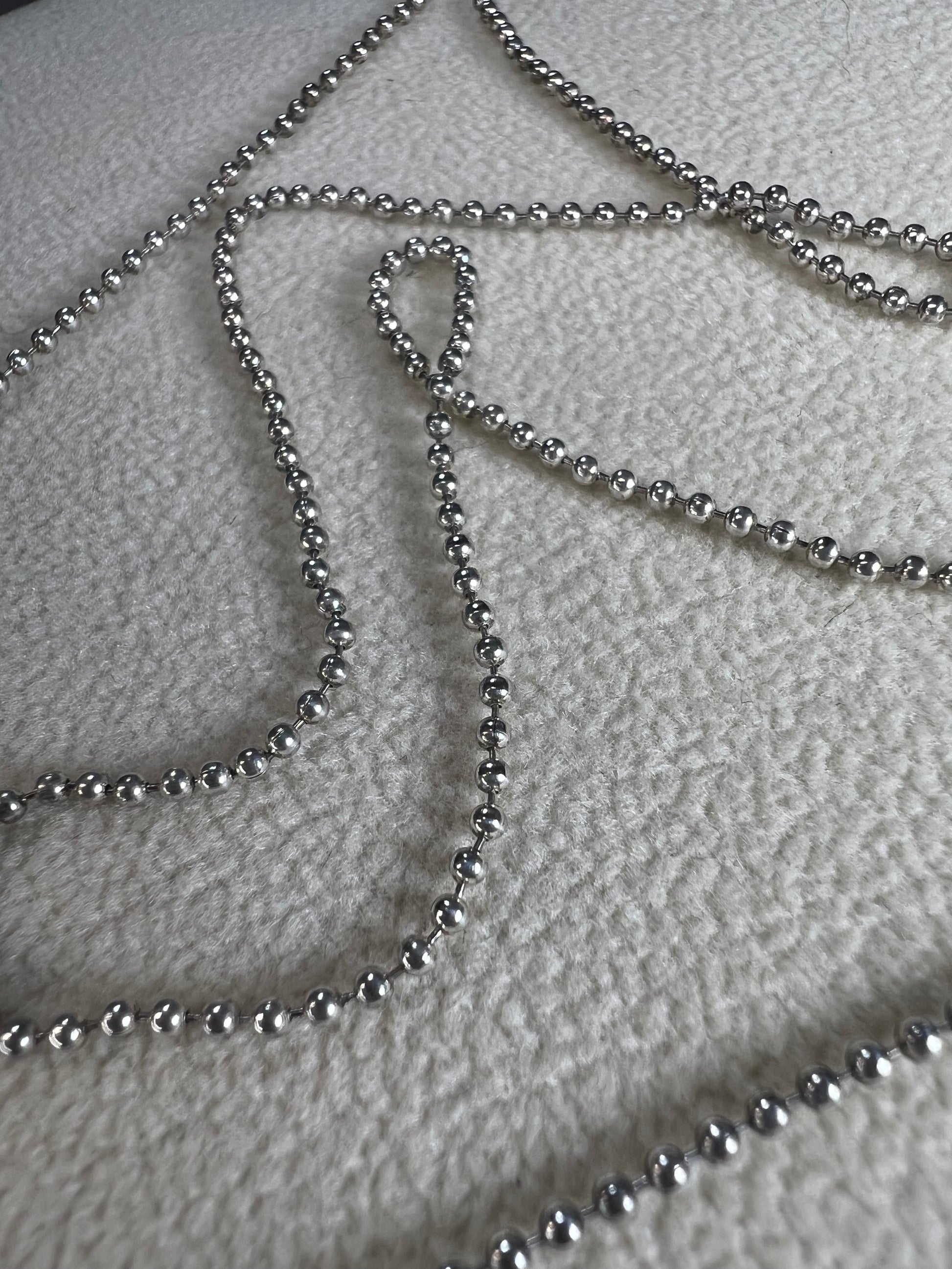This 24" sterling silver chain and double charm bead necklace brings graceful movement to your look throughout the day. Made in Italy.