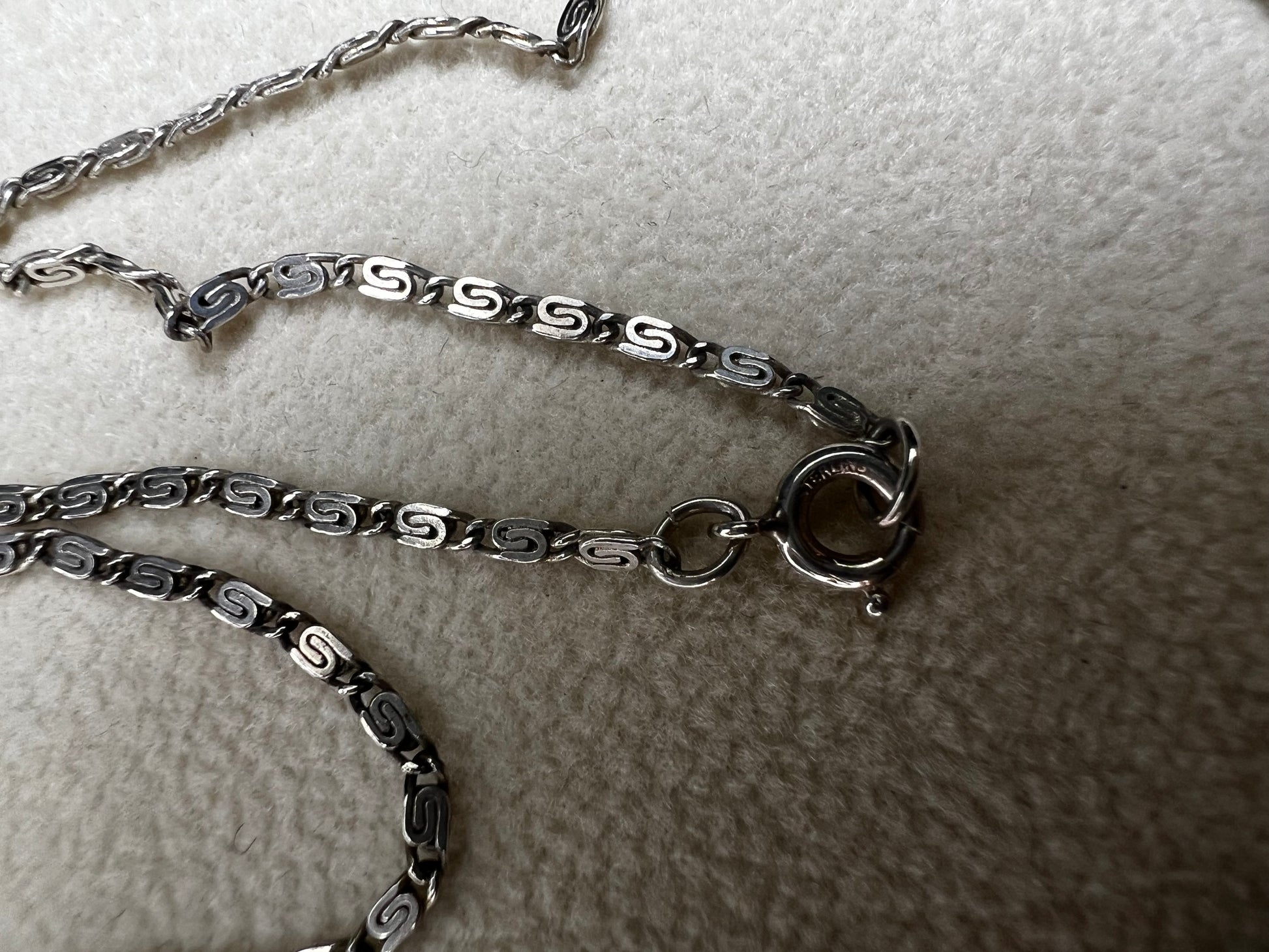 This 20" sterling silver scroll link chain paired with a faux turquoise pendant offers a timeless vintage style.