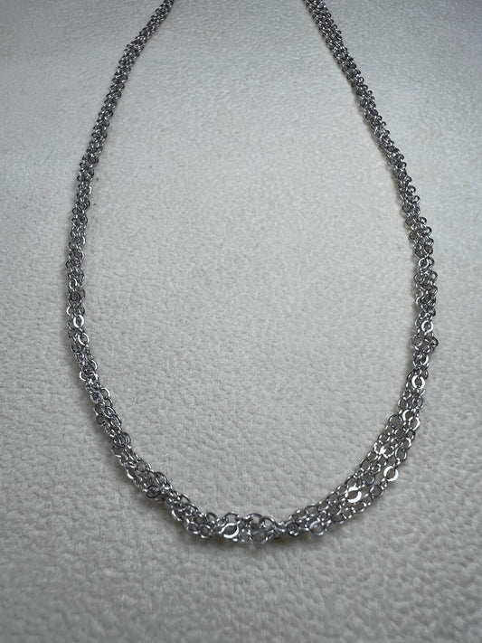This sterling silver multi-chain necklace features three delicate chains linked together, offering subtle movement and a graceful, layered look. Its versatile design adds a touch of elegance to any outfit.