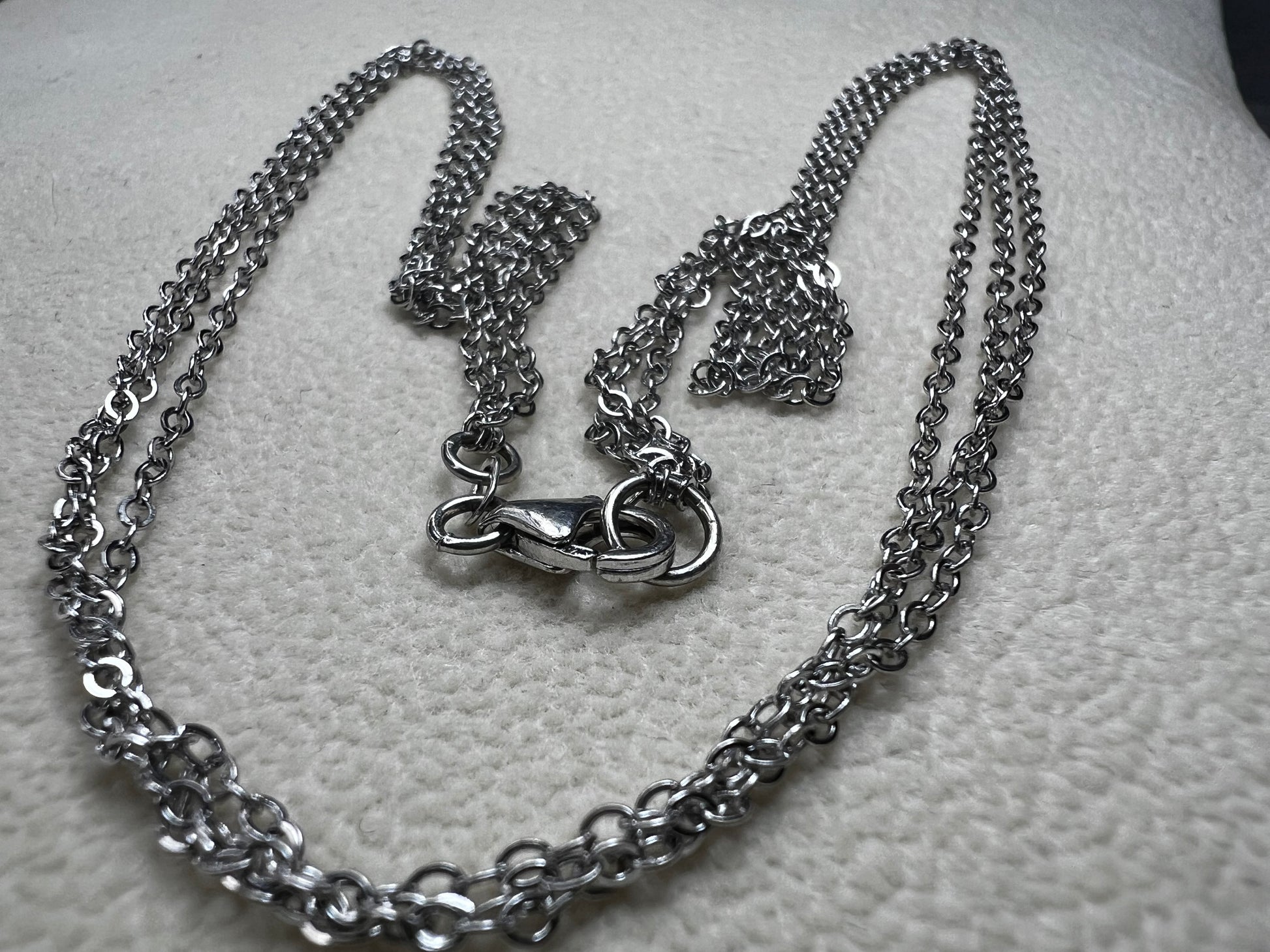 This sterling silver multi-chain necklace features three delicate chains linked together, offering subtle movement and a graceful, layered look. Its versatile design adds a touch of elegance to any outfit.