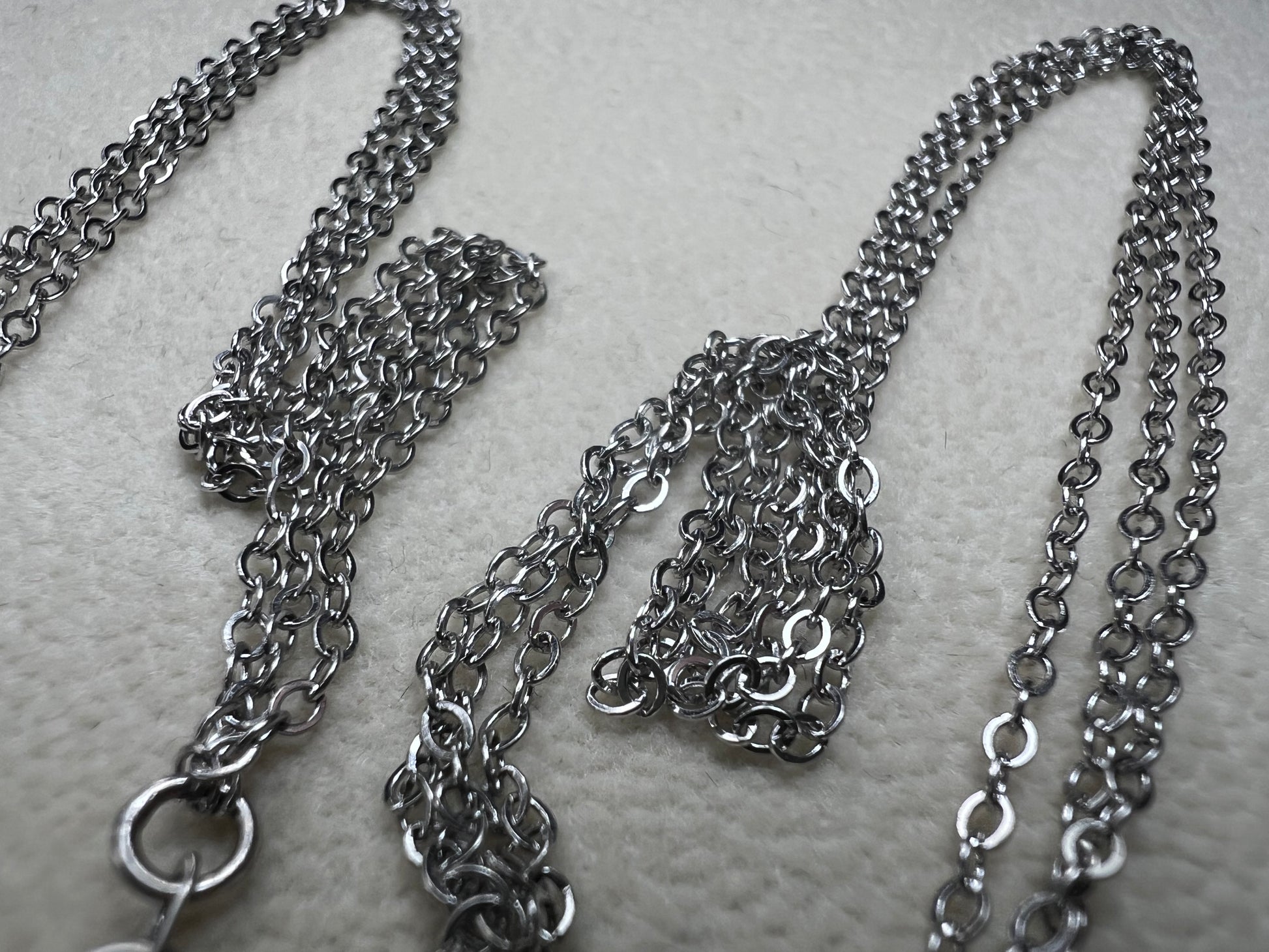 This sterling silver multi-chain necklace features three delicate chains linked together, offering subtle movement and a graceful, layered look. Its versatile design adds a touch of elegance to any outfit.