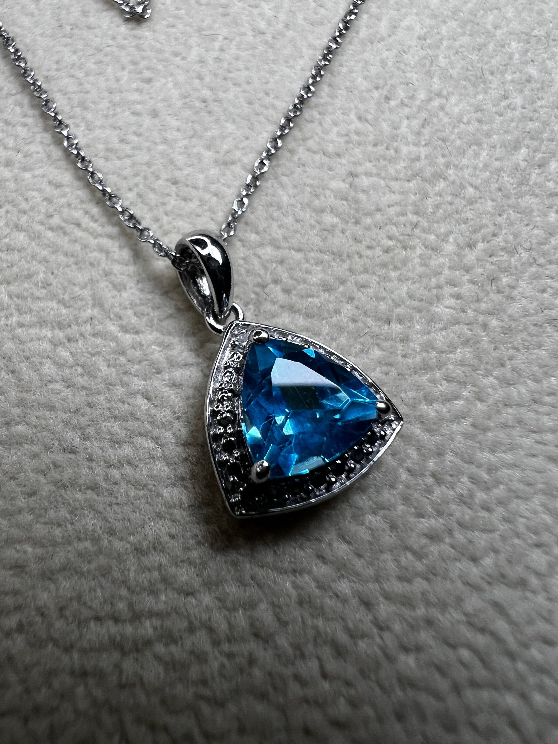 This 18" sterling silver chain paired with a petite blue topaz pendant offers a vibrant pop of color without overwhelming your look. Crafted for elegance and subtlety, it adds a refined sparkle that complements any outfit.