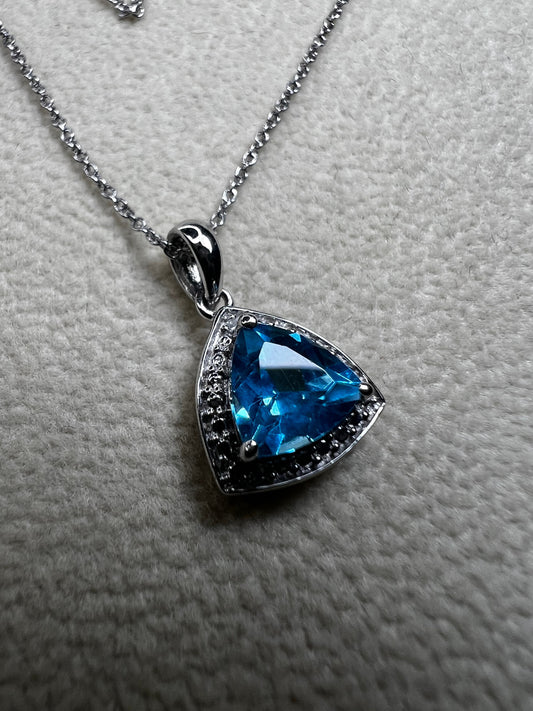 This 18" sterling silver chain paired with a petite blue topaz pendant offers a vibrant pop of color without overwhelming your look. Crafted for elegance and subtlety, it adds a refined sparkle that complements any outfit.