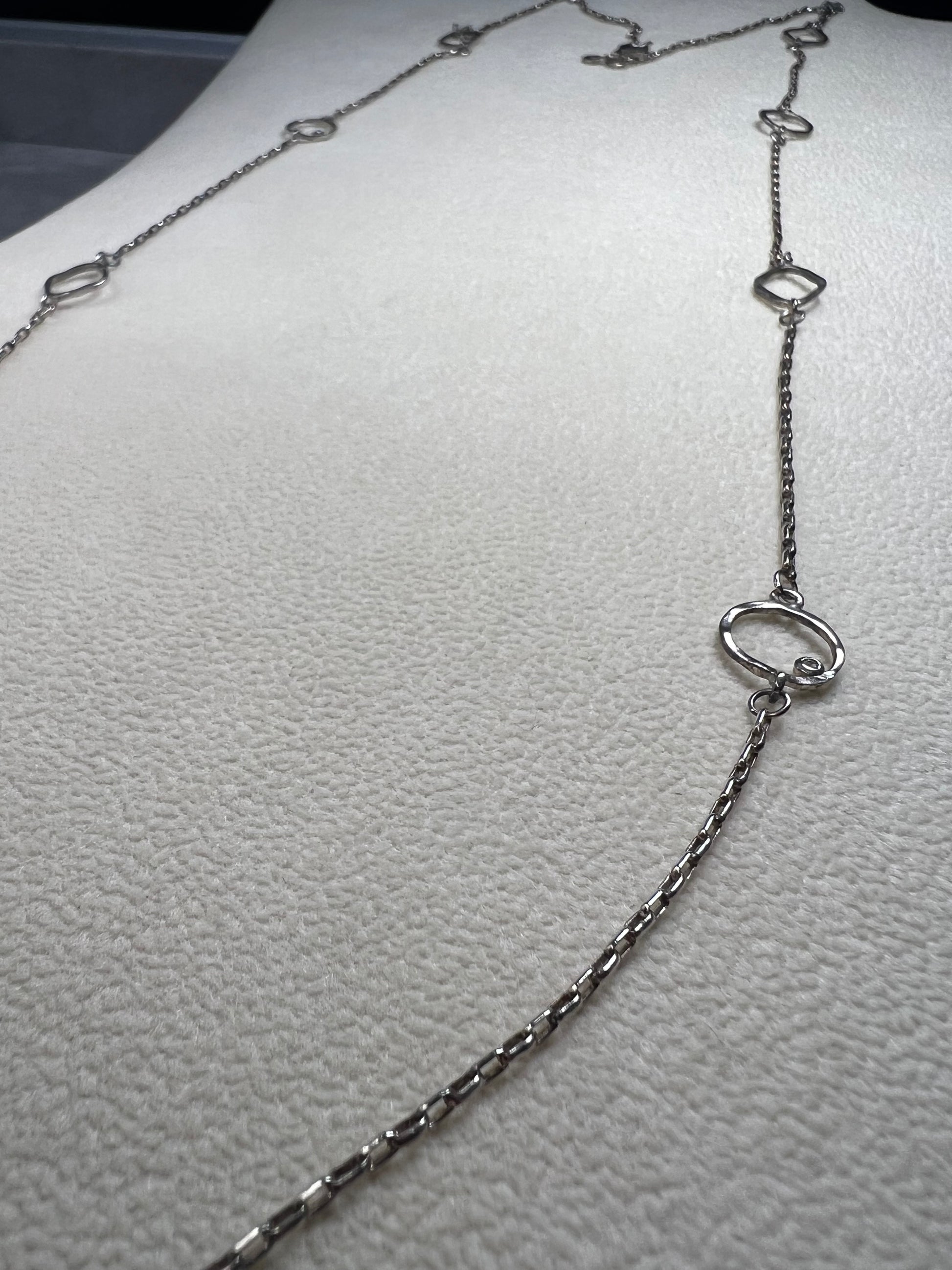 This retired Silpada necklace, measuring 34" in length, is crafted from sterling silver and accented with a few sparkling cubic zirconia stones. This "Ring Around the Rosy" necklace offers a subtle flash of light, making it a charming and elegant addition to any jewelry collection.