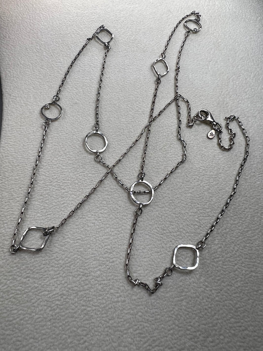 This retired Silpada necklace, measuring 34" in length, is crafted from sterling silver and accented with a few sparkling cubic zirconia stones. This "Ring Around the Rosy" necklace offers a subtle flash of light, making it a charming and elegant addition to any jewelry collection.