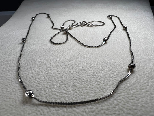This vintage Italian sterling silver necklace features 11 small sterling silver balls spaced apart, creating an elegant and distinctive design. Its timeless style makes it a versatile accessory that enhances any outfit with subtle sophistication.