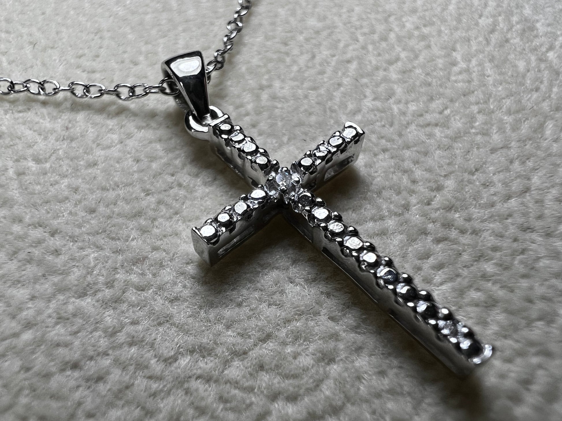 This sterling silver cross pendant necklace from V3 Jewelers features a single center diamond, combining classic design with subtle sparkle. This is a meaningful accessory that adds a graceful touch to any outfit while symbolizing faith and style.