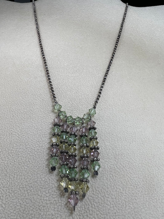 This vintage necklace features a sterling silver chain beautifully complemented by five crystal beaded strands that hang elegantly, creating a distinctive and timeless look.