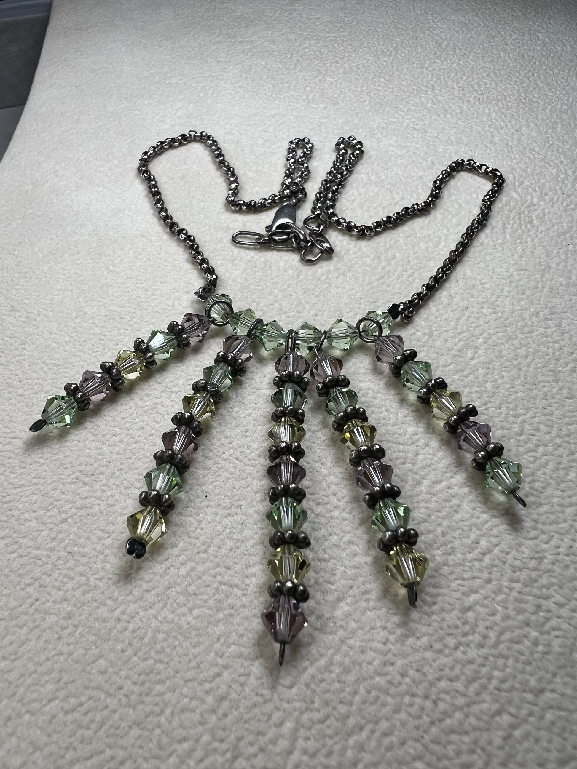 This vintage necklace features a sterling silver chain beautifully complemented by five crystal beaded strands that hang elegantly, creating a distinctive and timeless look.