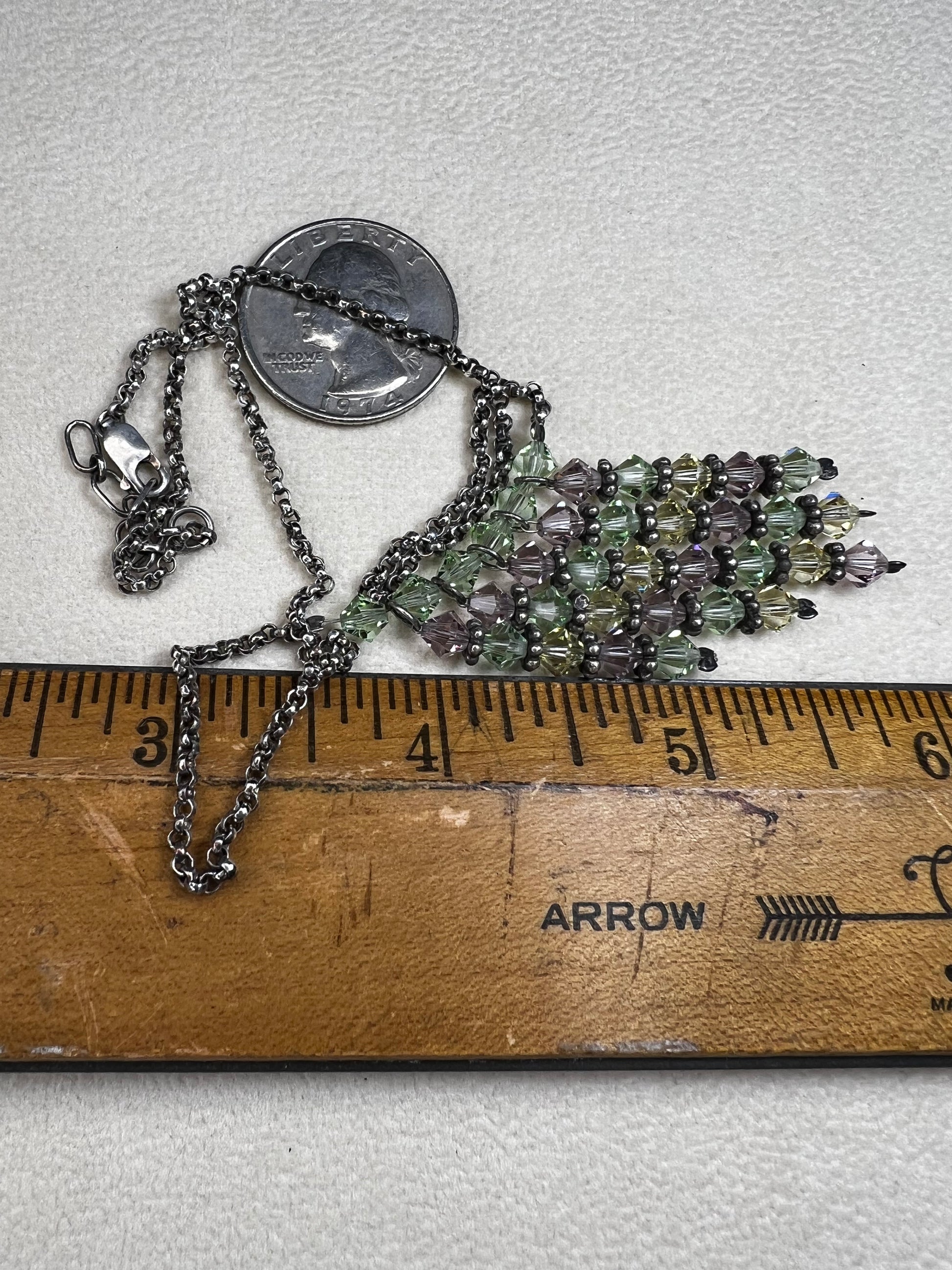 This vintage necklace features a sterling silver chain beautifully complemented by five crystal beaded strands that hang elegantly, creating a distinctive and timeless look.
