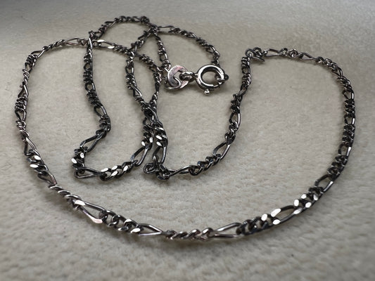 This 18" sterling silver chain from India features a classic Figaro link design, offering versatile style. It pairs perfectly with a small pendant or can be worn alone for a subtle, elegant touch to any look.