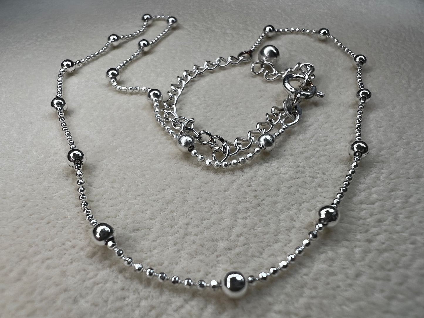 This 15" Italian sterling silver necklace features a bright finish that catches the light beautifully. Its delicate design combines tiny beads with slightly larger spaced beads, creating a simple yet striking accessory that adds subtle elegance to any outfit.