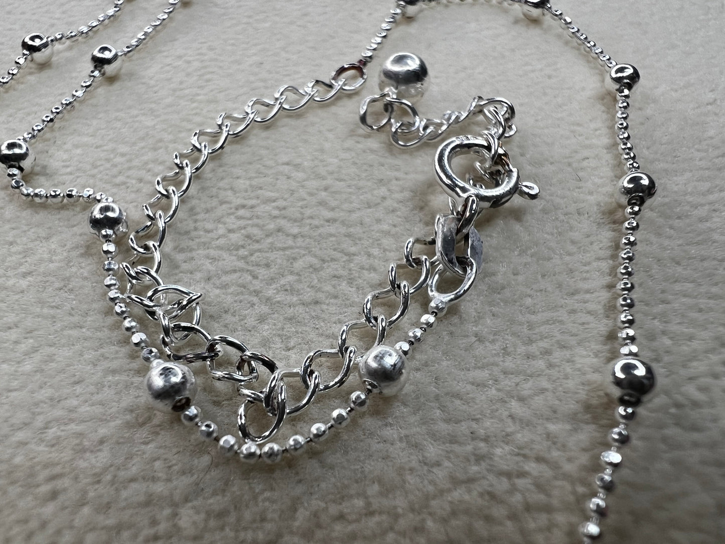 This 15" Italian sterling silver necklace features a bright finish that catches the light beautifully. Its delicate design combines tiny beads with slightly larger spaced beads, creating a simple yet striking accessory that adds subtle elegance to any outfit.