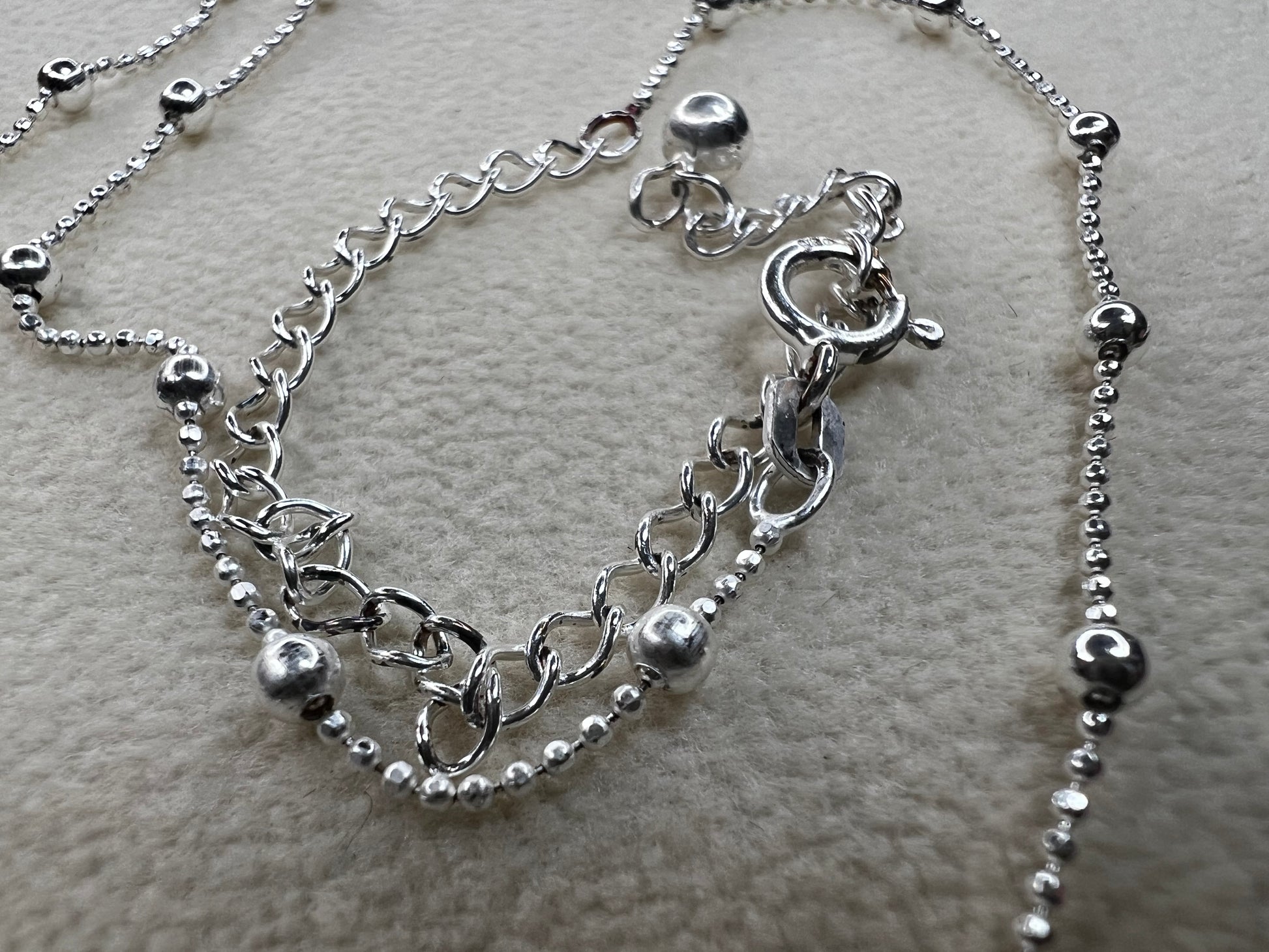 This 15" Italian sterling silver necklace features a bright finish that catches the light beautifully. Its delicate design combines tiny beads with slightly larger spaced beads, creating a simple yet striking accessory that adds subtle elegance to any outfit.
