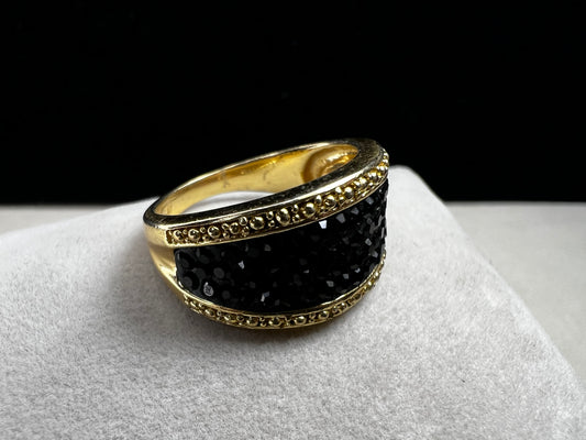 Crafted from sterling silver with a luxurious gold overlay, this ring features a cluster of black crystals nestled within a detailed frame. This piece offers both refined style and enduring sophistication.
