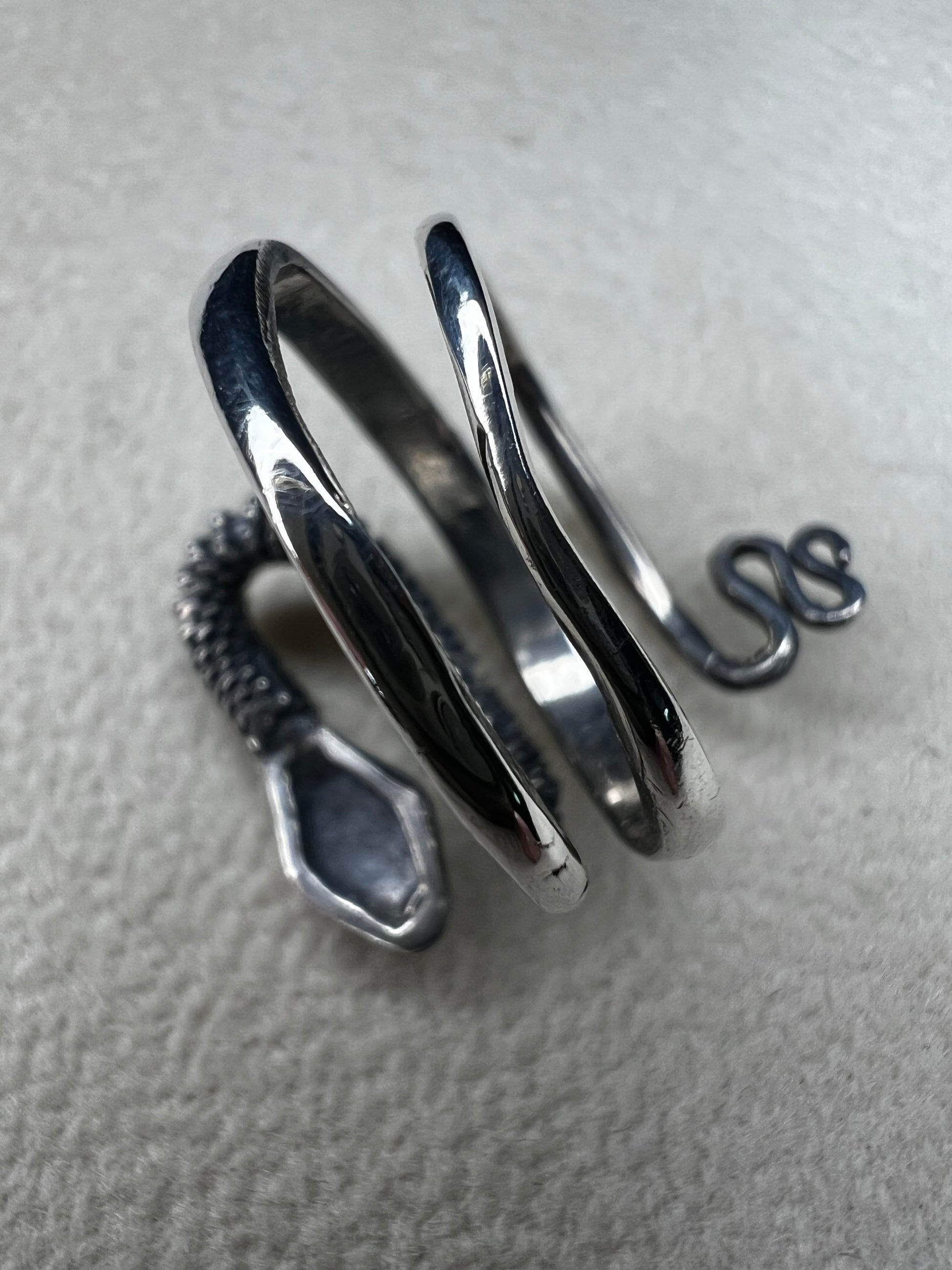 This sterling silver snake wrap ring gently coils around your finger with an open design, allowing for easy size adjustment. Its flexible fit ensures comfortable wear while adding a sleek, stylish touch to your collection.