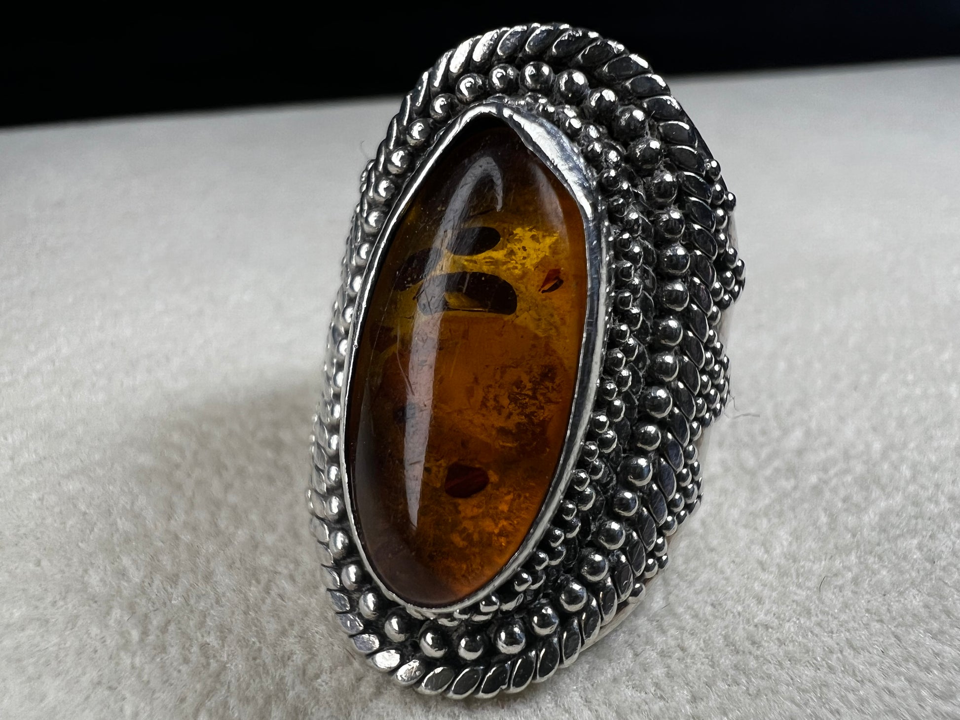 This vintage sterling silver ring features Balinese craftsmanship and a glowing amber cabochon. Made in Indonesia, it blends natural beauty with artisan elegance.