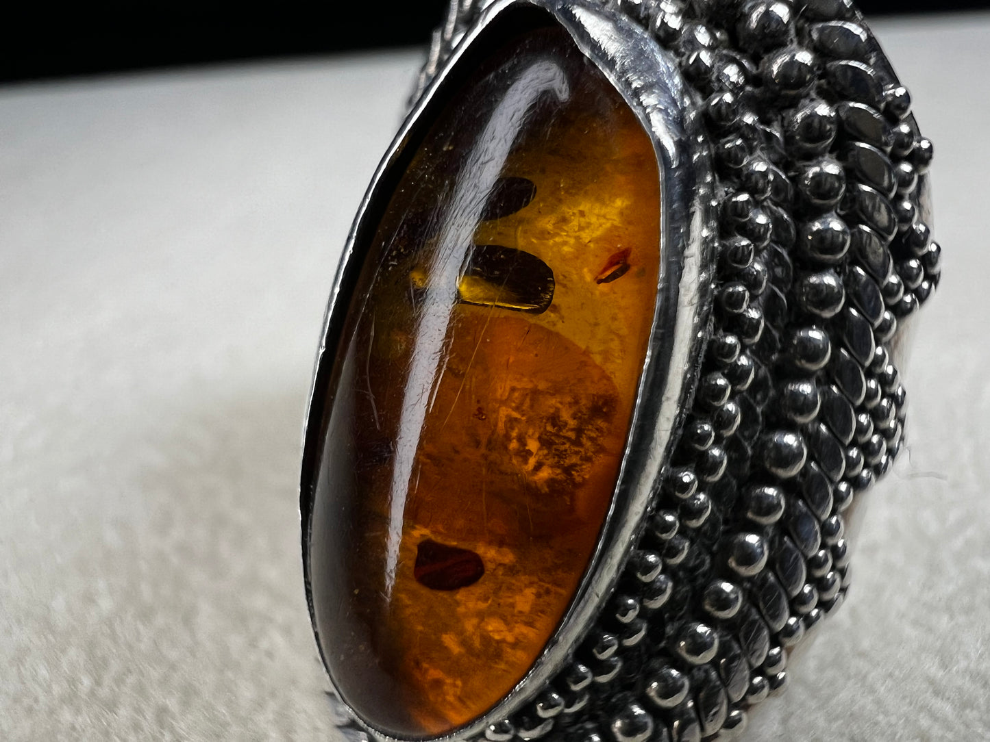 This vintage sterling silver ring features Balinese craftsmanship and a glowing amber cabochon. Made in Indonesia, it blends natural beauty with artisan elegance.