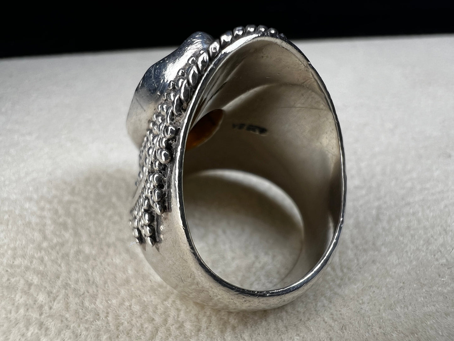 This vintage sterling silver ring features Balinese craftsmanship and a glowing amber cabochon. Made in Indonesia, it blends natural beauty with artisan elegance.